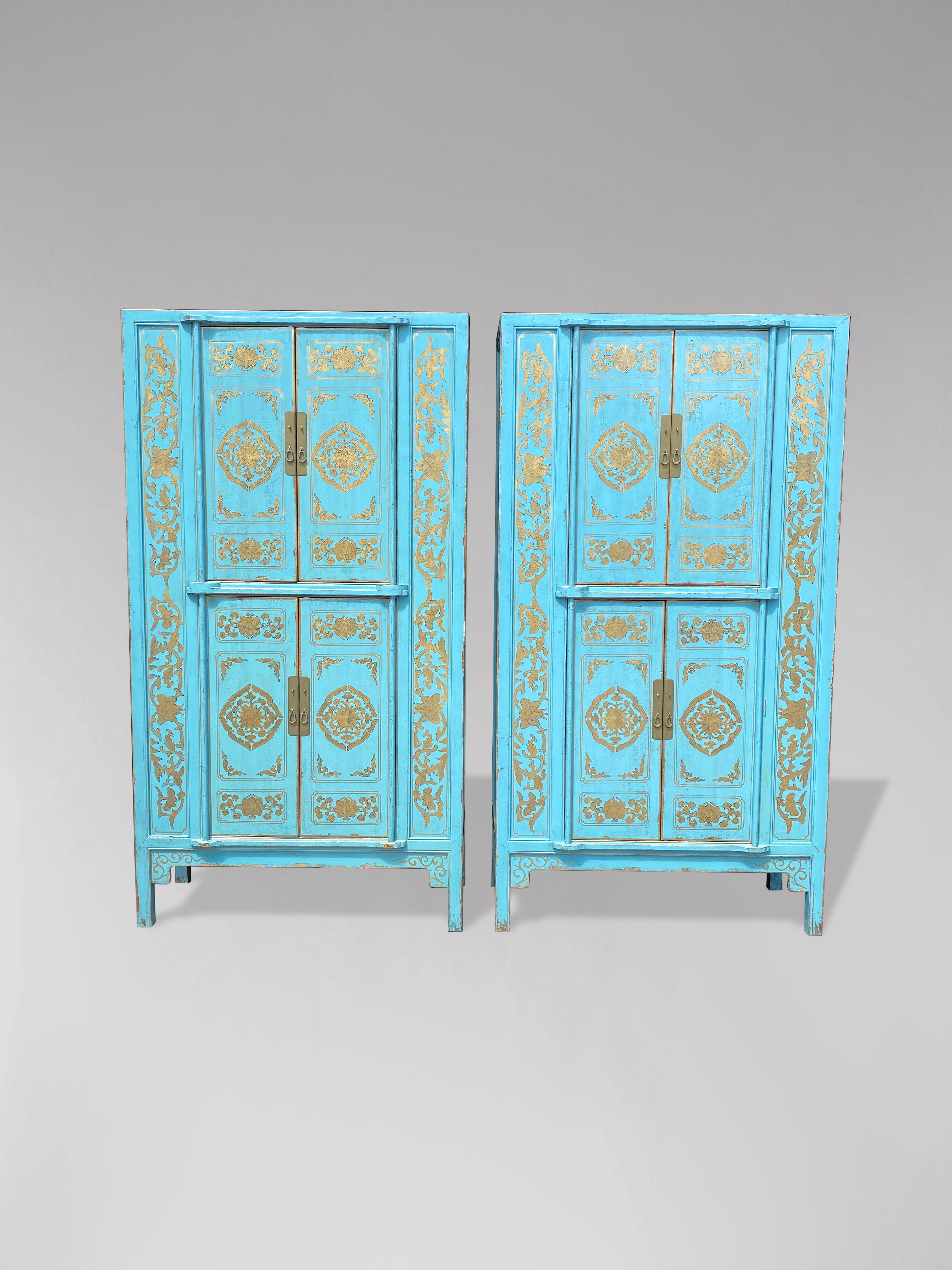 Pair of late 20th century turquoise painted with gold motifs tall cupboards. Each cupboard with 4 doors enclosing a shelf and plenty of storage. Four large compartments to each cupboard offering plenty of storage space. The doors are richly
