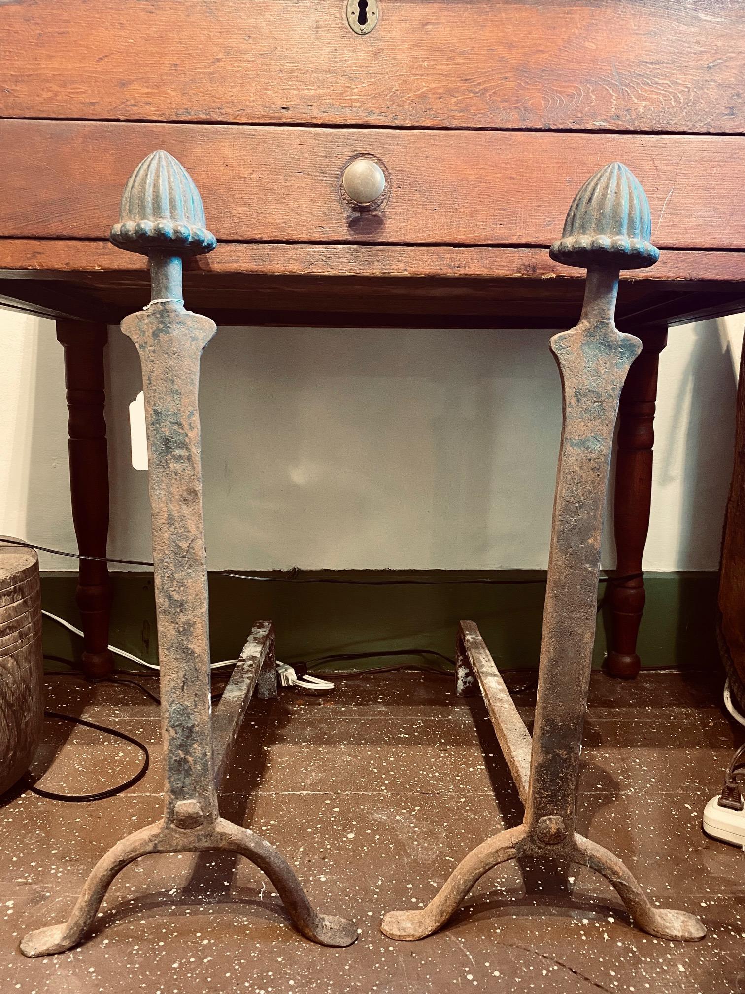 Pair of Late Colonial or Early Federal Iron Acorn Finial Andirons, circa 1800, an unusual and impressively large pair of cast iron andirons with a large fluted acorn finial atop a heavy knife blade standard, raised on arched legs ending in penny
