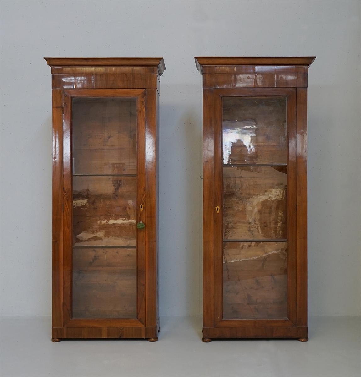 Pair of Late Empire style bookcases. Small in size, they are composed of elements in solid walnut and others in folder and feature a wick shellac finish. Large glass door and internal shelves with ladder shelves. They comes with original shelves