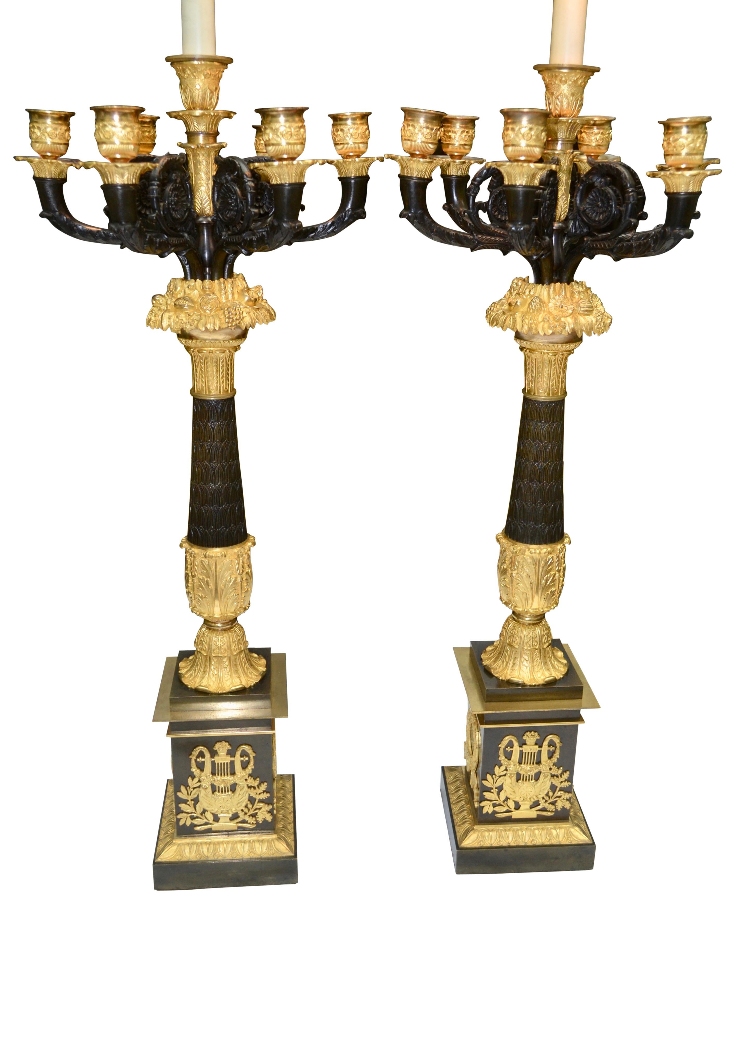A pair of French Empire candelabra/lamps of the finest quality patinated and gilt bronze, likely the work of the one of the preeminent Parisienne bronziers perhaps Galle or Thomire. The central patinated column decorated with leaves and flowers is