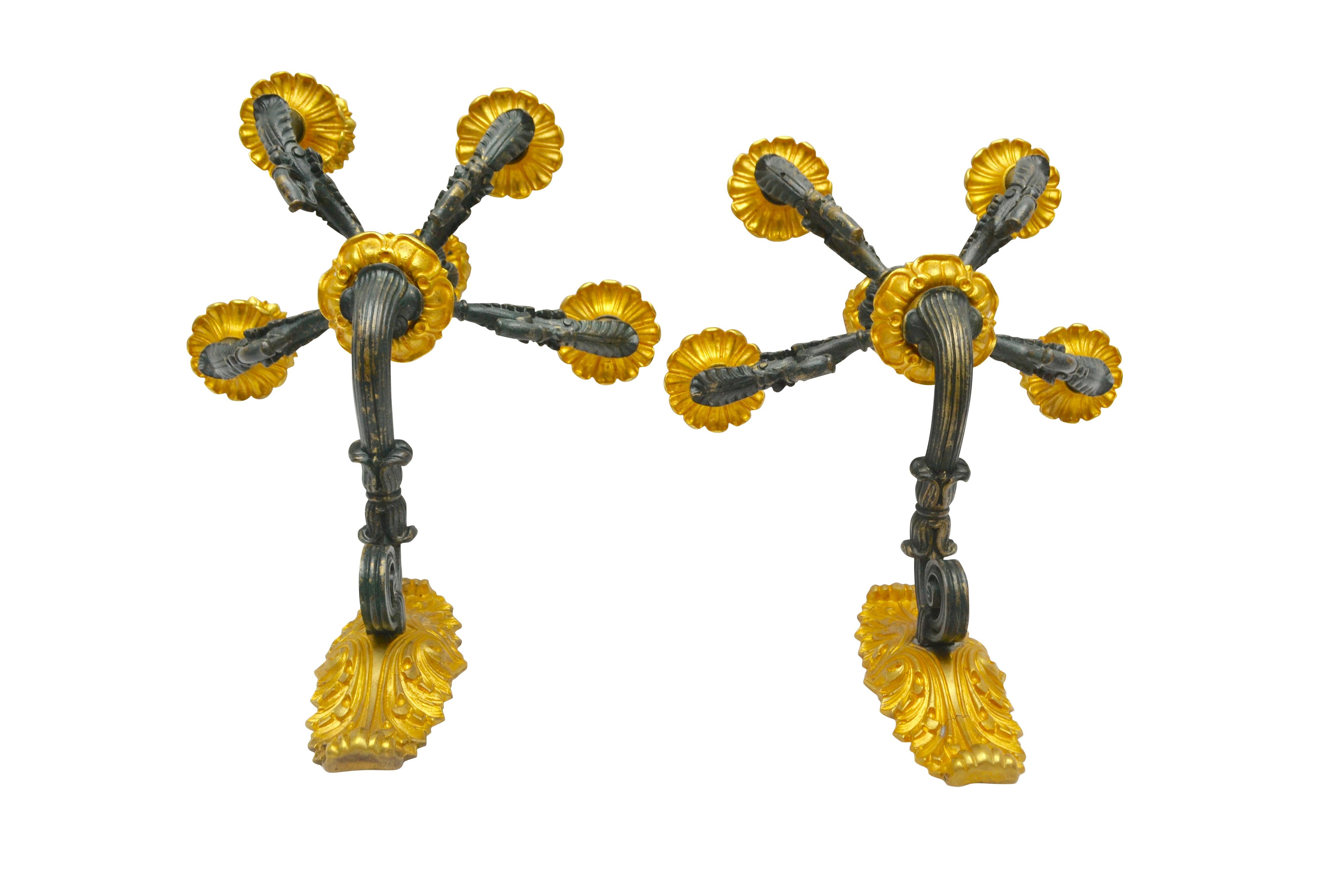 Coppia di appliques della metà del XIX secolo in stile Impero/Restaurazione francese. La piastra posteriore in bronzo dorato sostiene un braccio in bronzo patinato da cui partono quattro bracci e un braccio centrale. I grandi gocciolatoi inferiori e