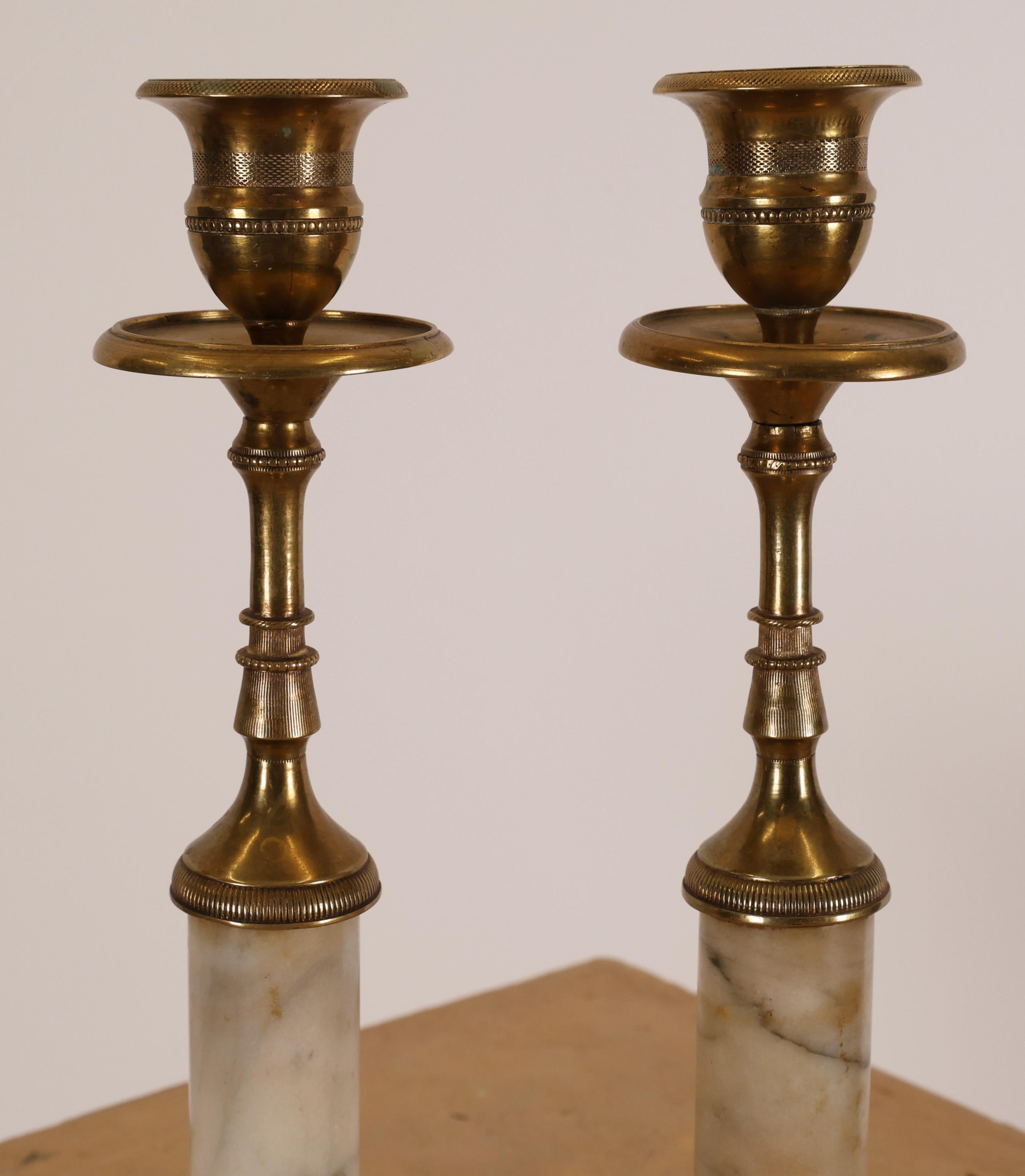 A pair of Swedish late Gustavian candleholders in white Carrara marble and fire-gilded bronze.
