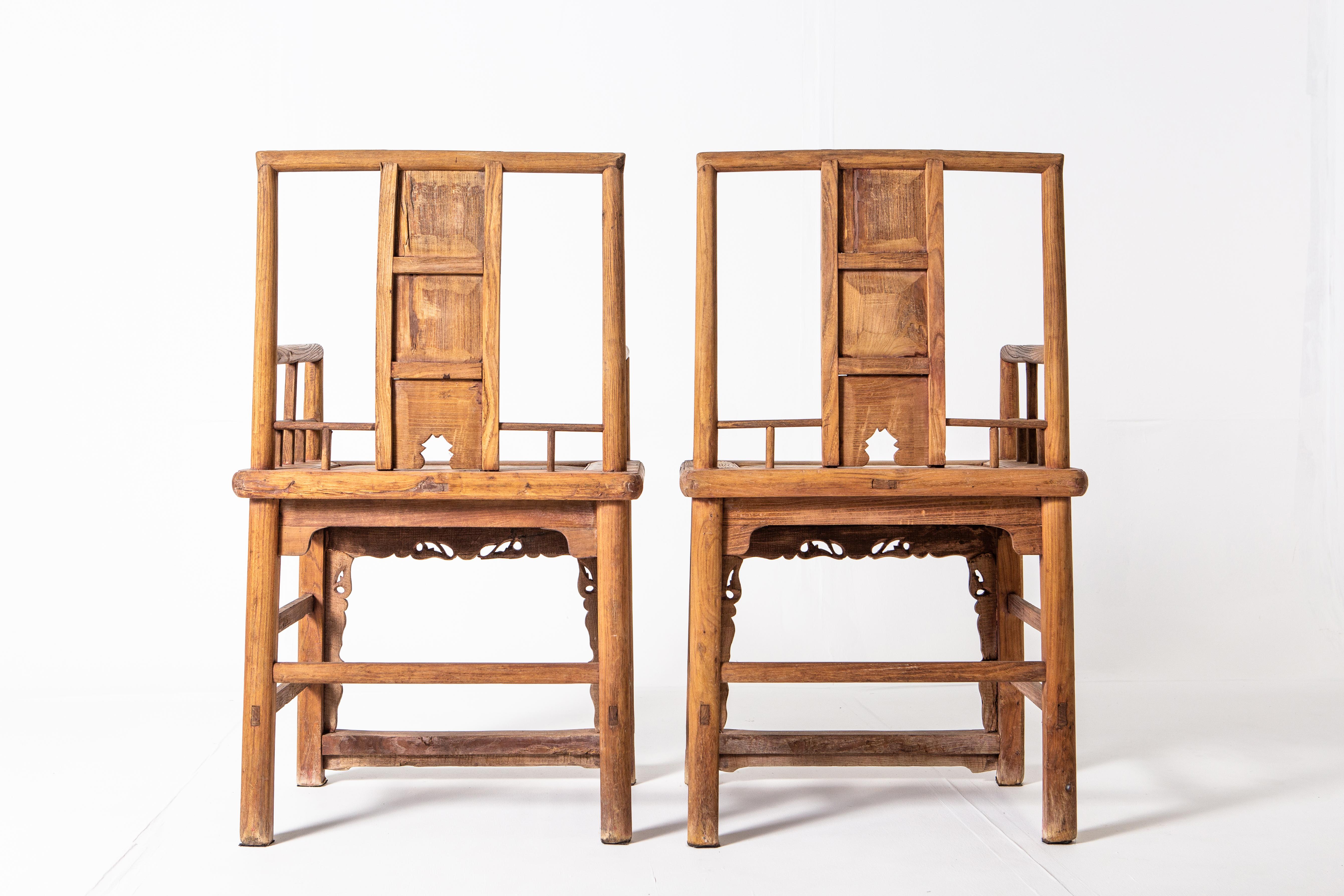 These beautiful elm wood chairs feature a rounded frame construction with intricately carved Chinese motifs. Dating back to the late-Qing dynasty, the honey color of the elm and the weathered feet shows a beautifully aged patina.