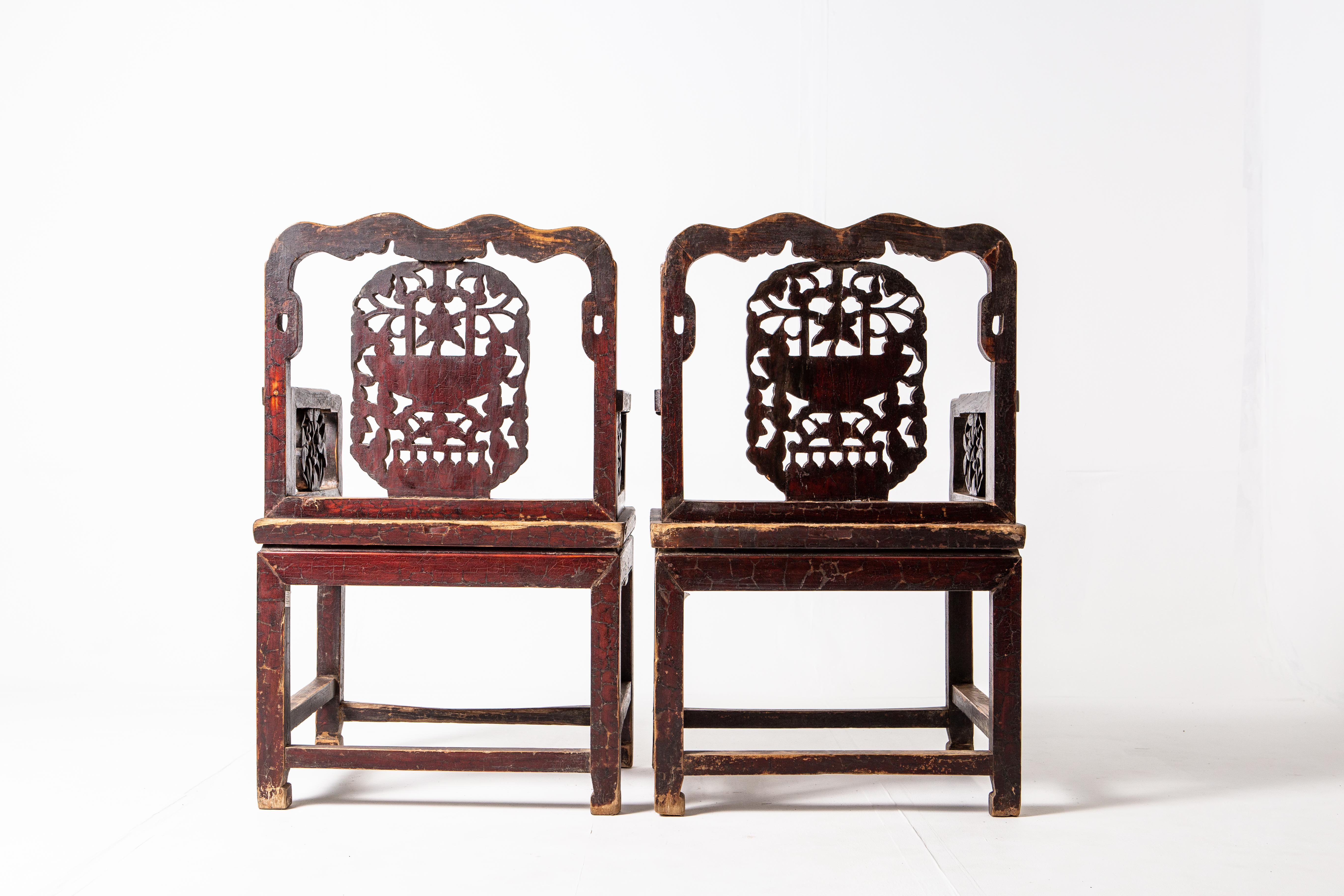 These handsome elm chairs feature botanic carvings and scrollwork on their apron. Dating to the late-Qing Dynasty, the chairs are made up of two parts: a waisted stool and an upper back-rest that resembles a screen panel. Stout and with a generous