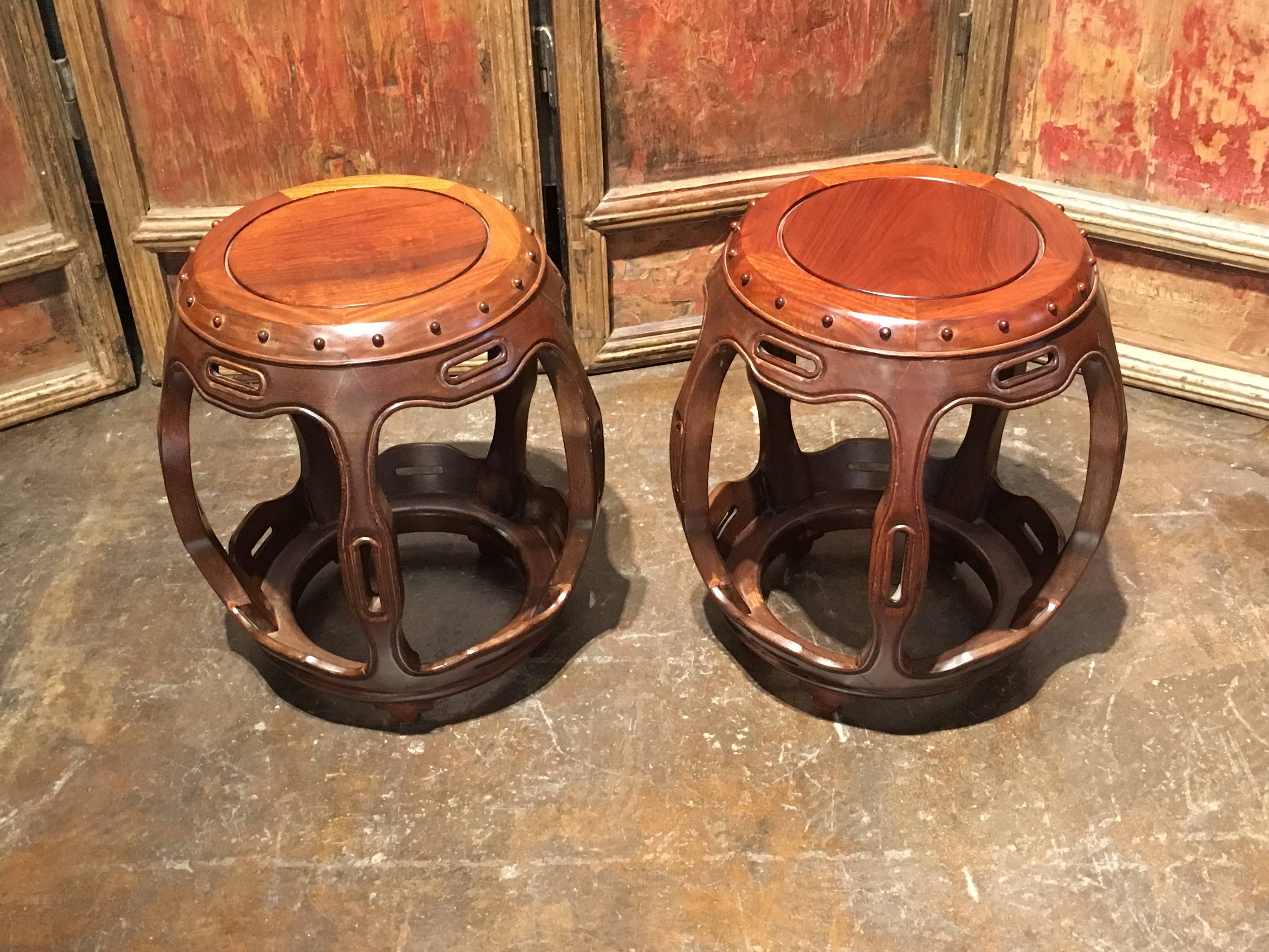 An elegant pair of late Qing dynasty Chinese drum-form barrel stools made of precious hongmu, a type of rosewood.
Suitable for use as either stools or side tables, the pierced ribs curve slightly outward, accentuating the overall roundness of the