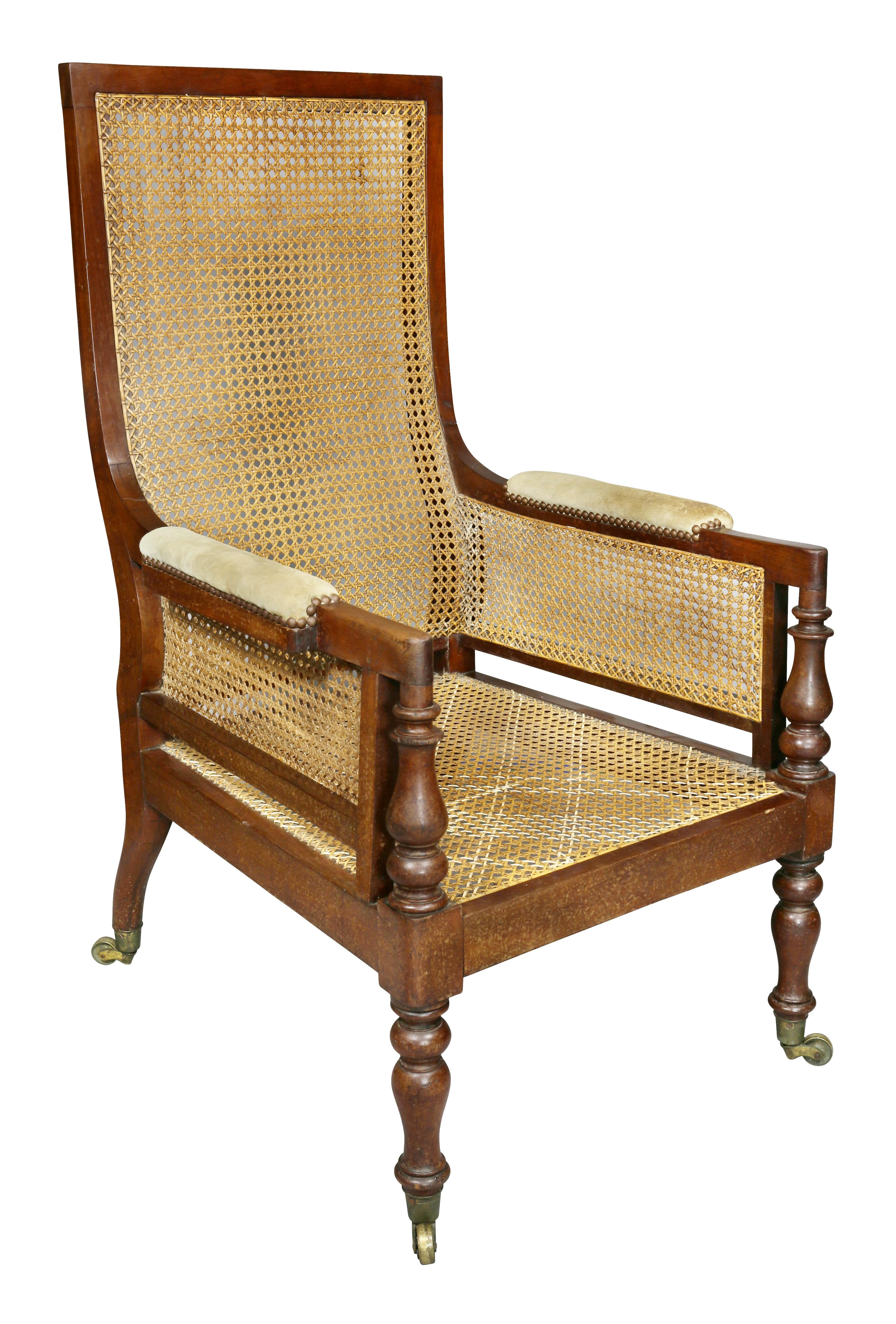 Each with a high square back, caned overall, turned arm supports, raised on turned tapered legs, casters.