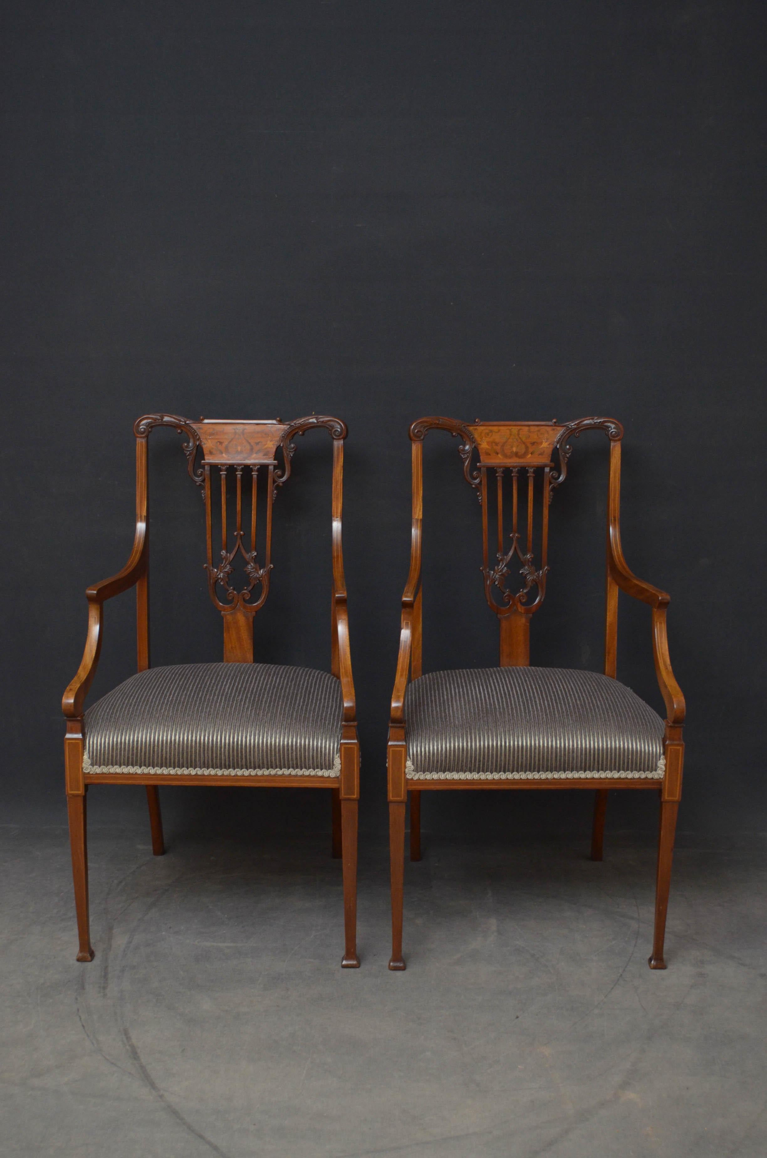 Sn4794 Superb pair of mahogany elbow chairs, each having finely carved rail with inlaid splat and carved slats above newly covered overstuffed seat and satinwood string inlaid open arms, standing on tapered legs terminating in pad feet. This pair of
