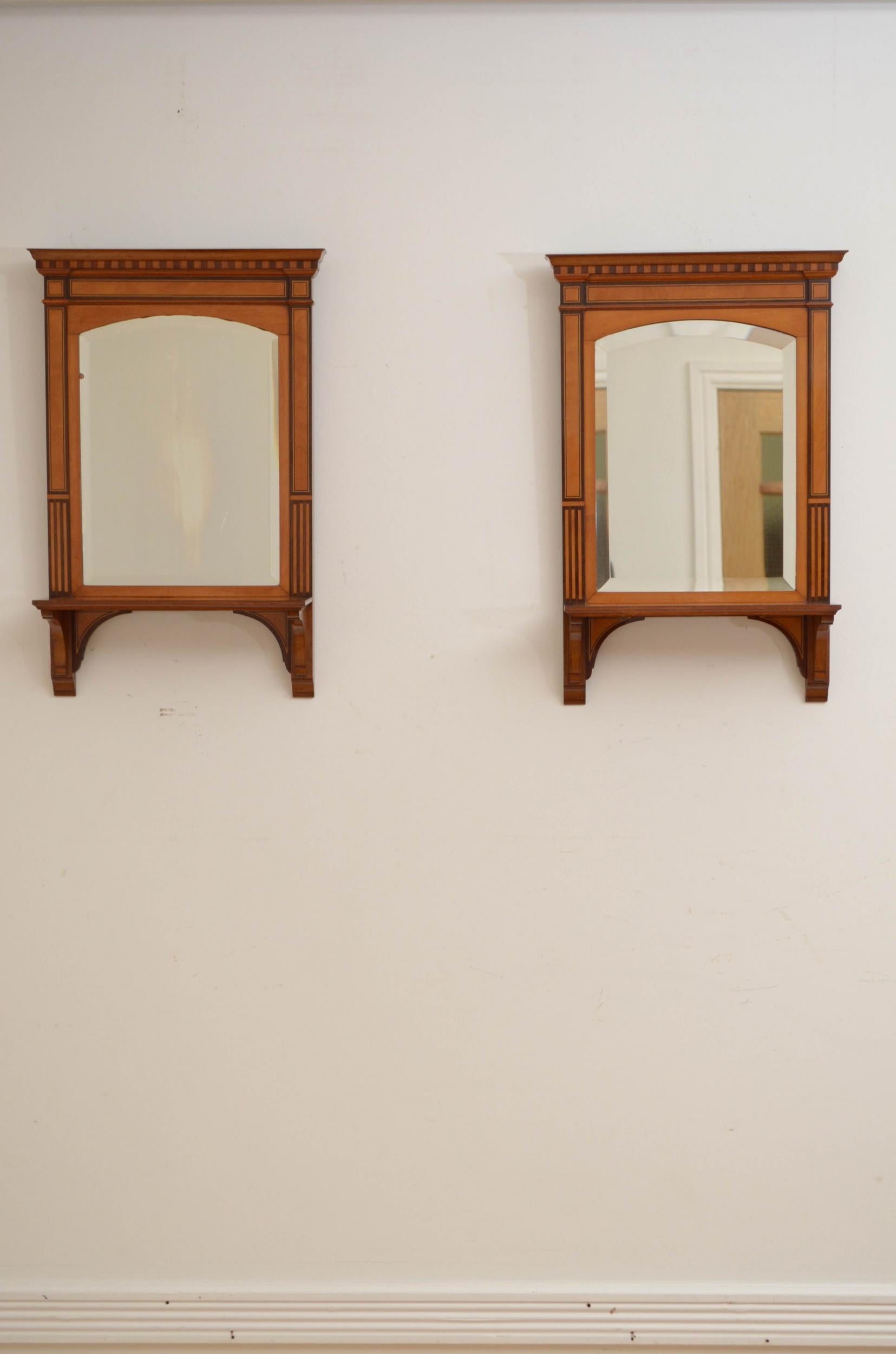 Sn5053, pair of fine quality satinwood wall mirrors, each having original bevelled edge arched mirror with some imperfections in satinwood fame with moulded cornice above dentil inlaid frieze, mahogany banded uprights and crossbanded shelf supported