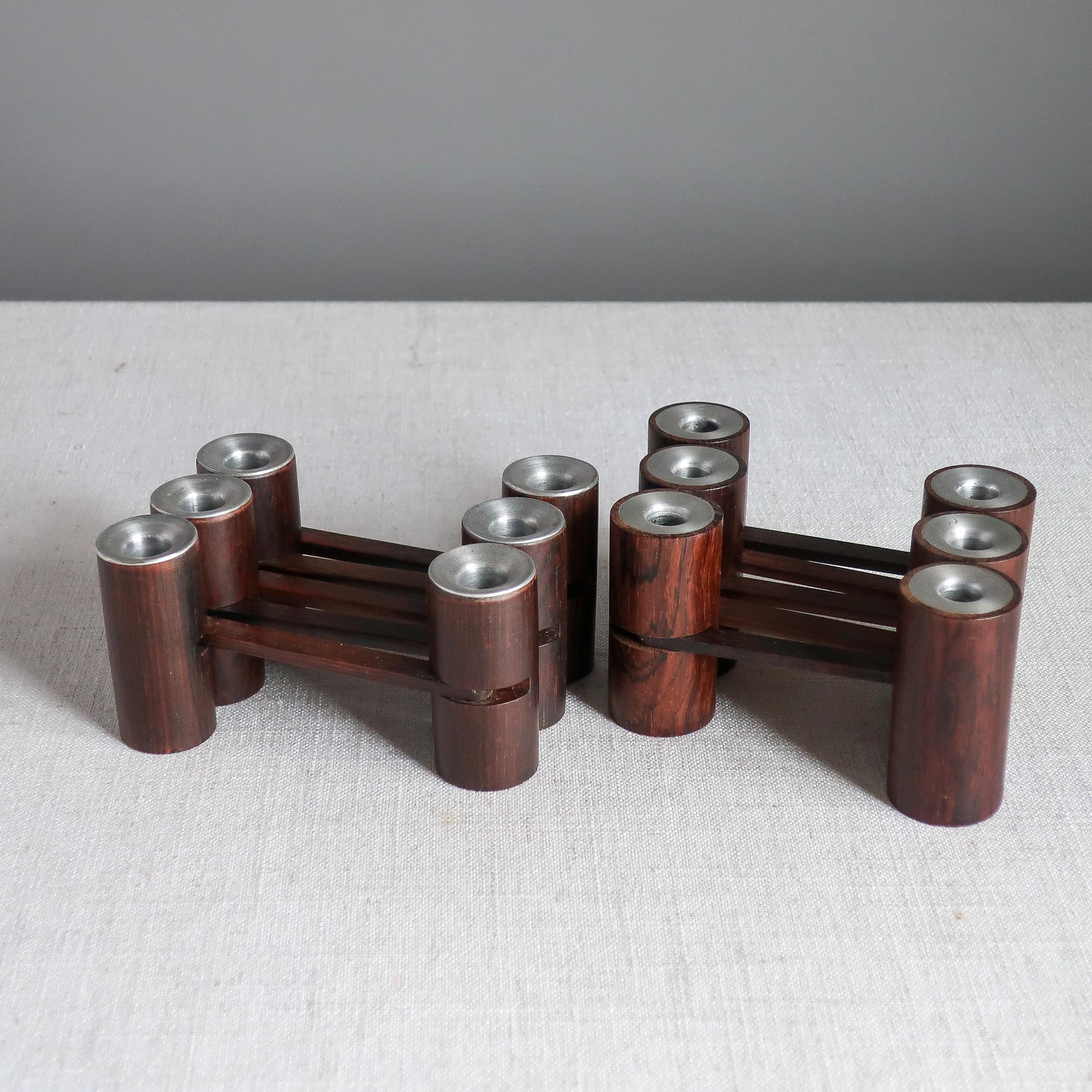Pair of rosewood and aluminum articulated candelabra by Lauritz Jensen. Made in Denmark, each is comprised of six cylindrical candleholders, jointed so that they can be arranged in any way. Marked with paper label, the LJ mongram, and
