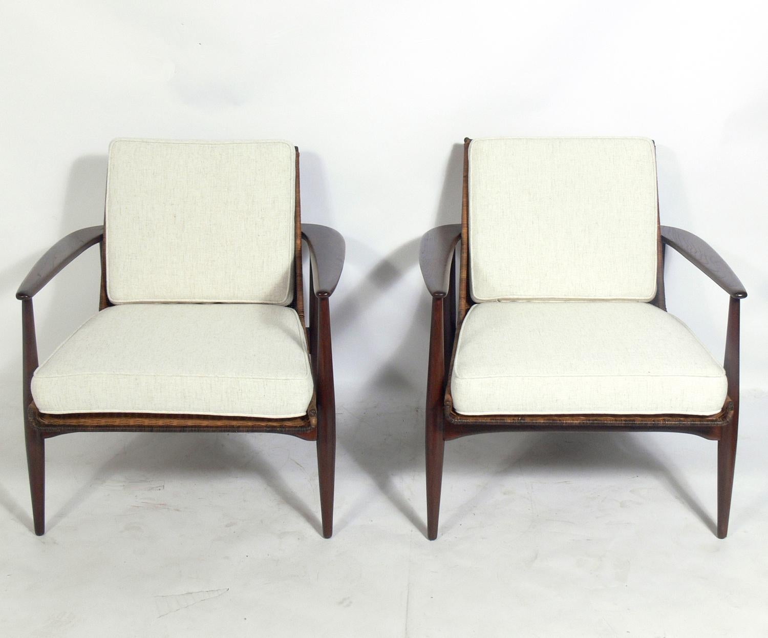 Pair of midcentury walnut and rattan lounge chairs, designed by Lawrence Peabody for Richardson Nemschoff, American, circa 1950s. The walnut has been refinished and the cushions have been reupholstered. Rattan retains warm original patina.