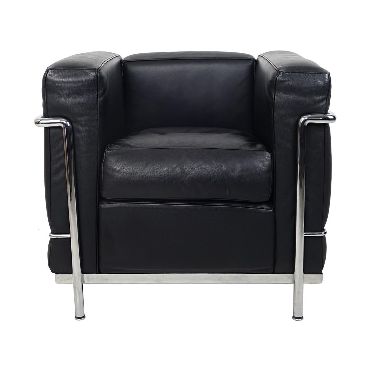 Pair of armchairs LC2 Petit Modèle with polished chrome frame and separate black leather cushions. 
The LC2 was designed in 1928 by Le Corbusier and Charlotte Perriand and ever since it has been the archetypal Modernist armchair that never seems to
