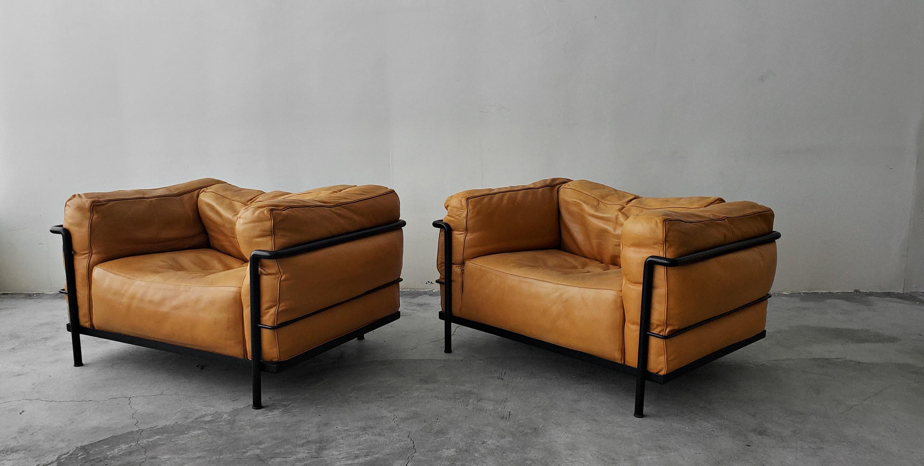 A rare pair of authentic, vintage LC3 Grand Modele armchairs with down cushions. Chairs are the super rare black frames with beautiful, butter soft cognac colored leather. The LC3's were designed by Le Corbusier, Pierre Jeanneret and Charlotte