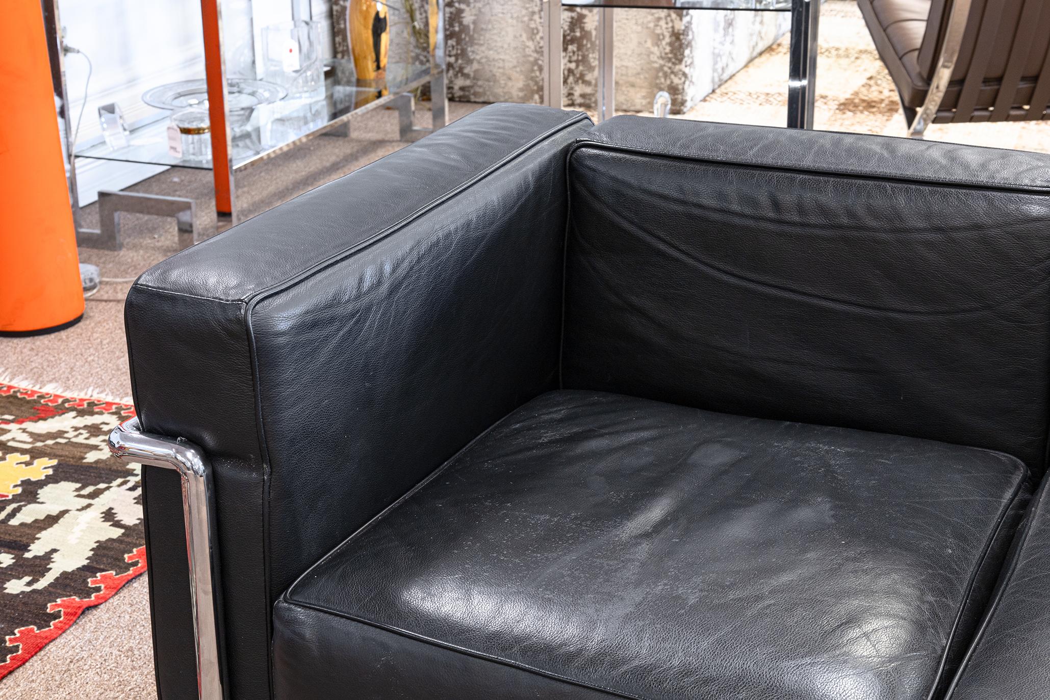 A pair of Le Corbusier LC2 style chrome and black leather sofas. A gorgeous pair of mid century modern sofas. These pieces feature fully removable black leather seat cushions, back cushions, and side armrest cushions. They all fit very snuggly into