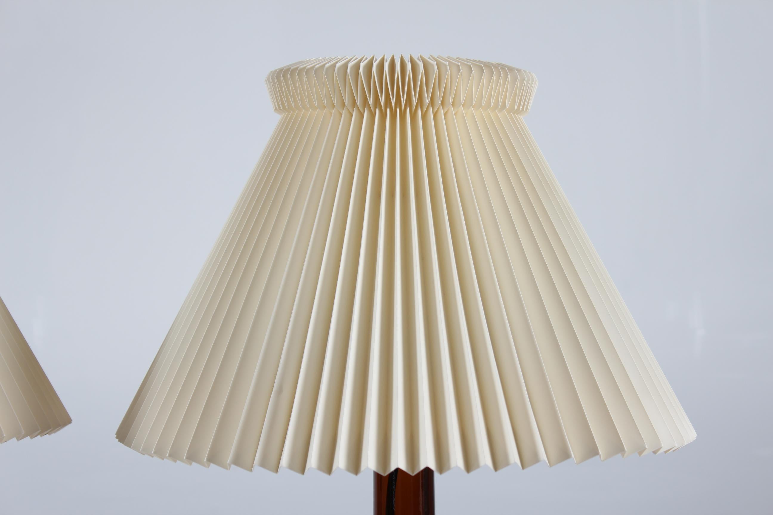 A pair of Danish table lamp model 343 by designer by Biilmann-Petersen 
The lamp foots are made of mouth blown translucent dark amber or brown colored glass from Holmegaard glass works and comes with vintage original Le Klint lamp