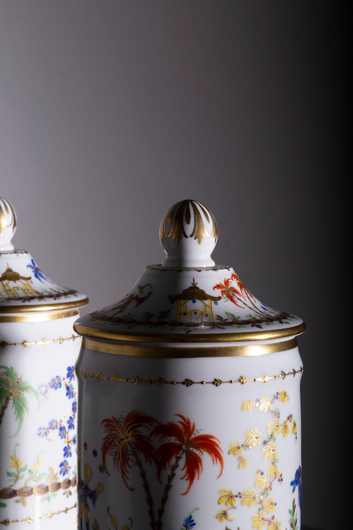 Vor uns entfaltet sich ein Paar Apothekendosen aus exquisitem Porzellan, die die Signatur von Le Tallec tragen - ein authentisches Meisterwerk, das über ein reines Kunstwerk hinausgeht. Diese Gläser verkörpern eine fesselnde Geschichte und zeitlose
