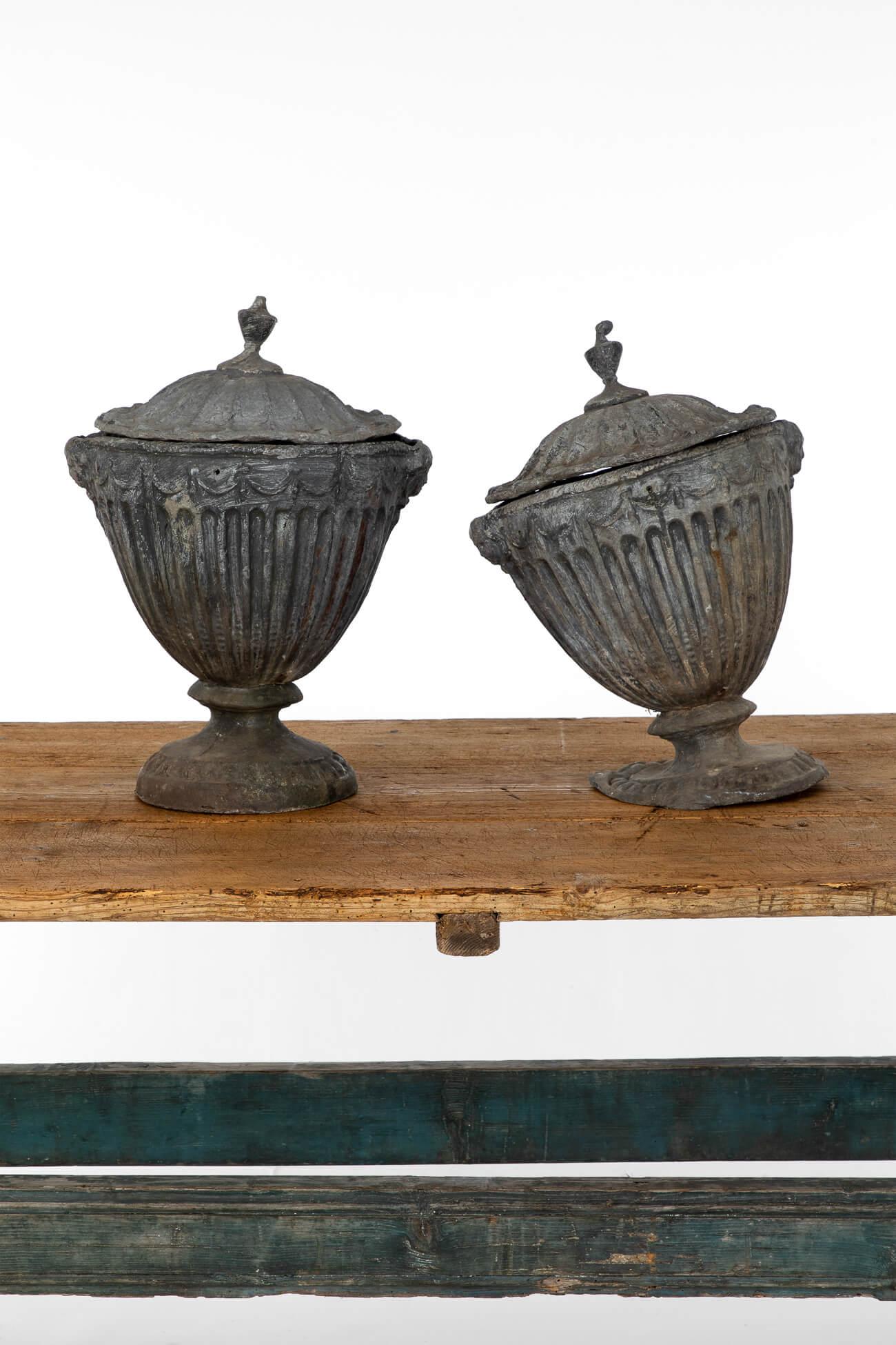 A fabulous pair of lead urns based on the design of the British Georgian architect Robert Adam.

Neoclassical in design with fluted decoration to the sides and base.

The urns are heavily weighted as fitting the original designs from circa