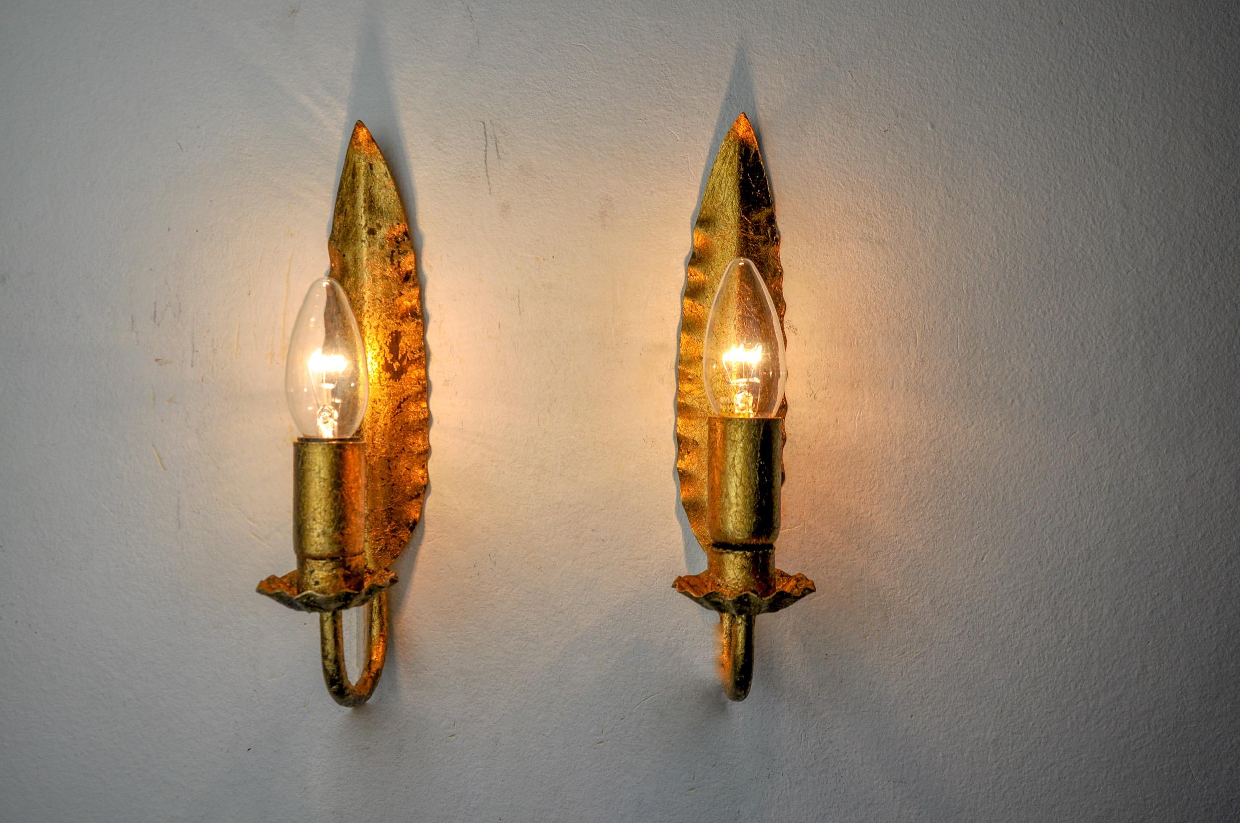 Very beautiful and rare pair of midcentury wall lights in the shape of a leaf designated and produced by Ferro Arte in Spain in the 1960s, in metal and made with gold leaf. Rare design object that will illuminate your interior wonderfully.