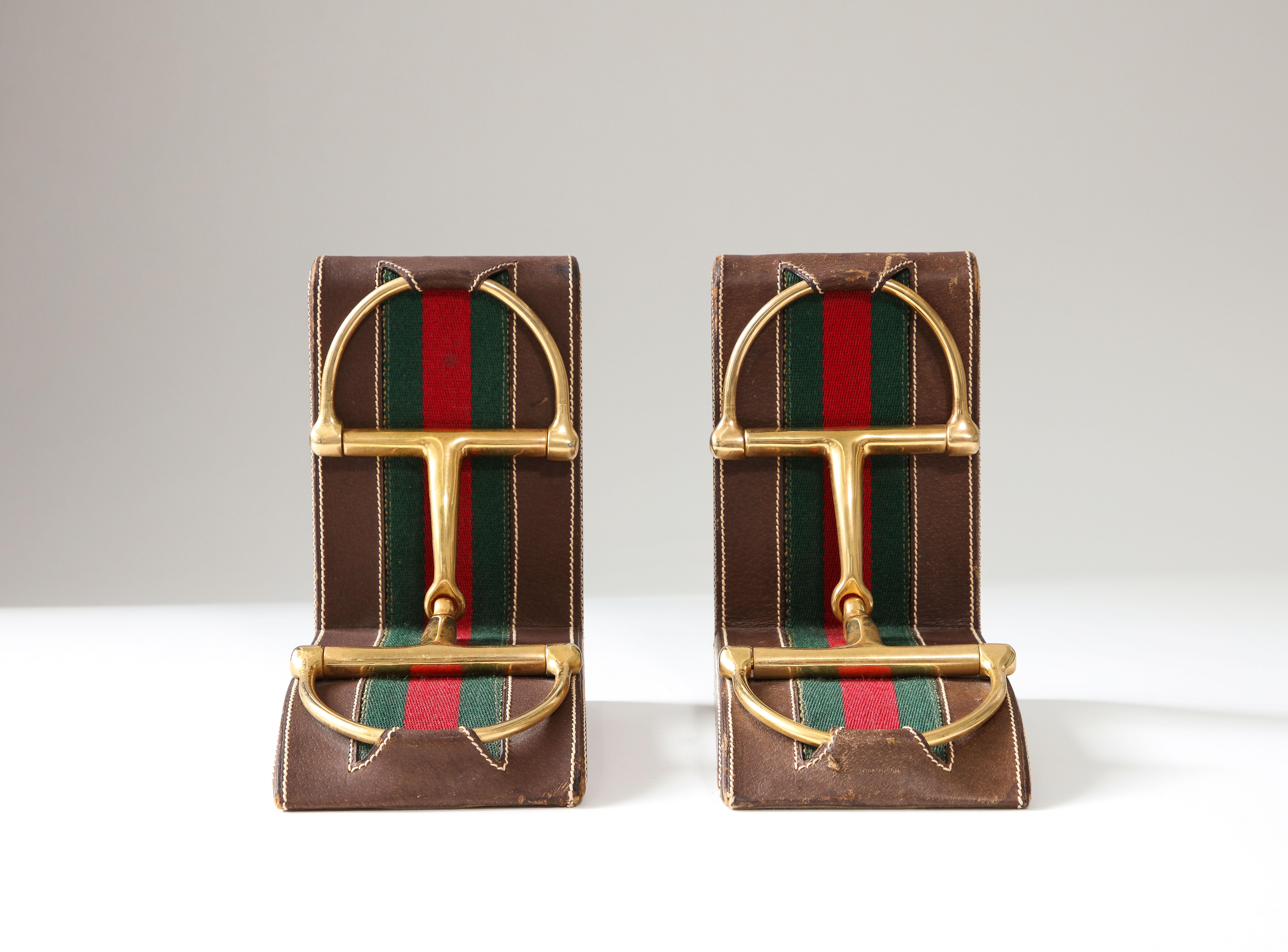 Classic, refined bookends from Gucci, decorated with patinated brass horsebits and a contrast stitched leather.