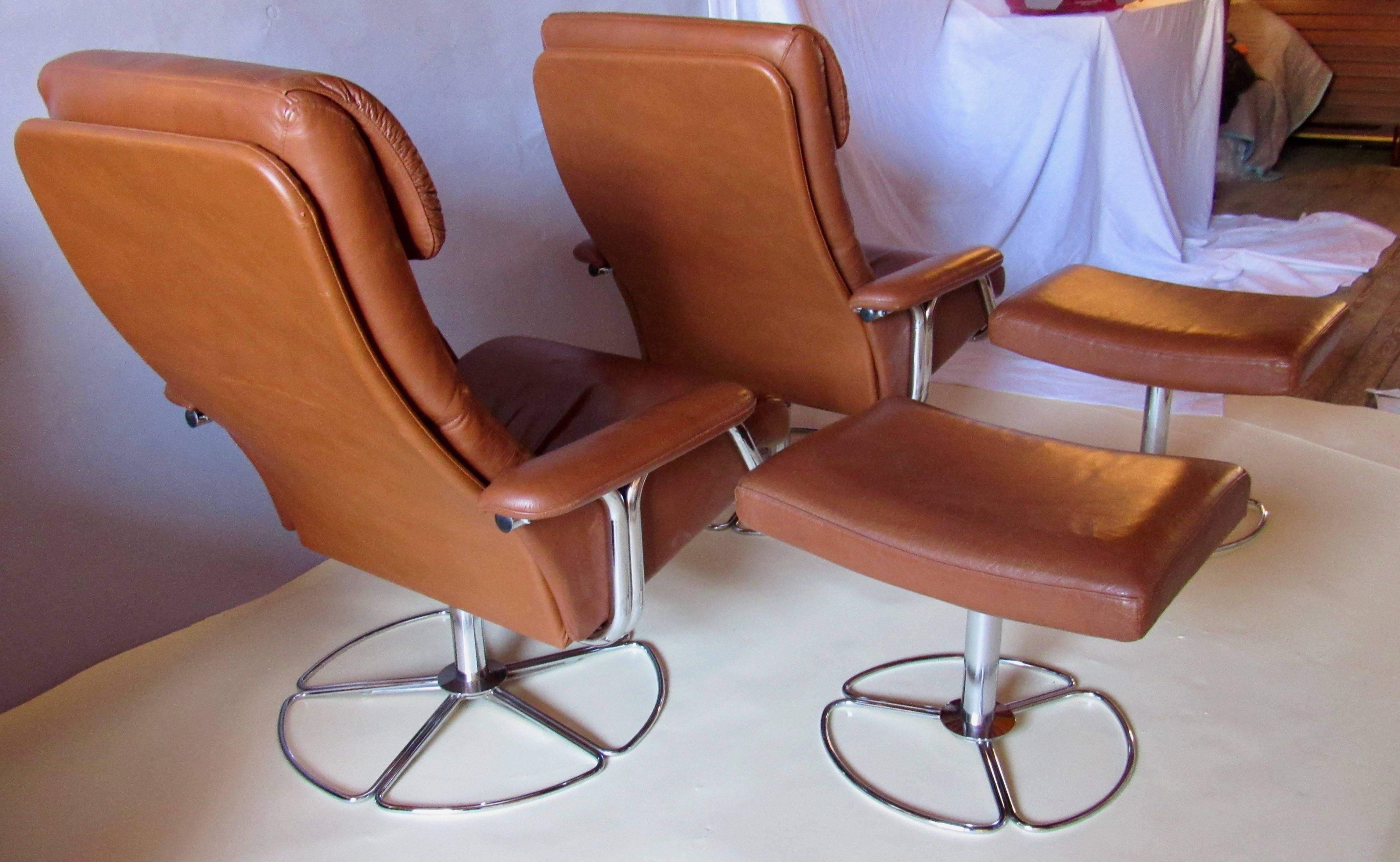 A rare pair of Bruno Mathsson for DUX of Sweden leather and chrome swivel lounge chairs and ottomans imported by Finmark, Inc.
According to Pamono and 1stdibs this is a DUX product designed by Bruno Matsson.  
Labeled 