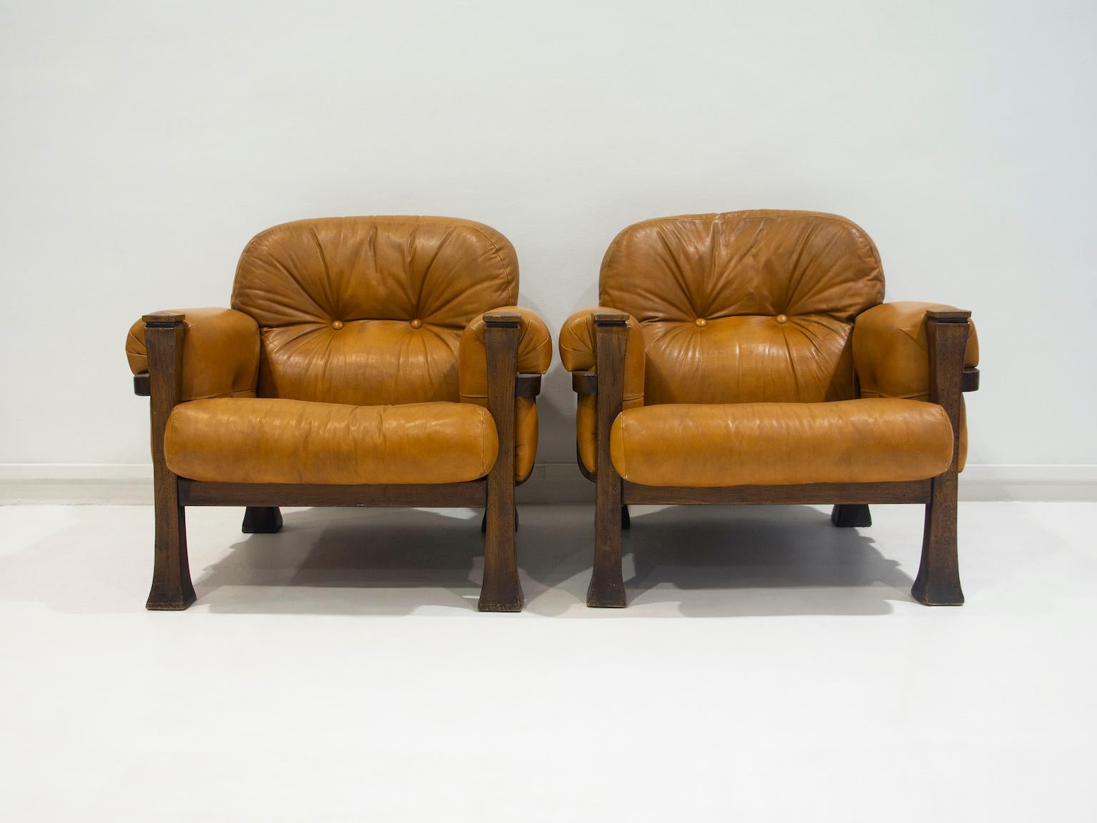 Pair of lounge chairs made in Brazil in the 1960's. The armchairs feature a solid wood frame and a caramel colored leather upholstery. The design is attributed to Percival Lafer. 