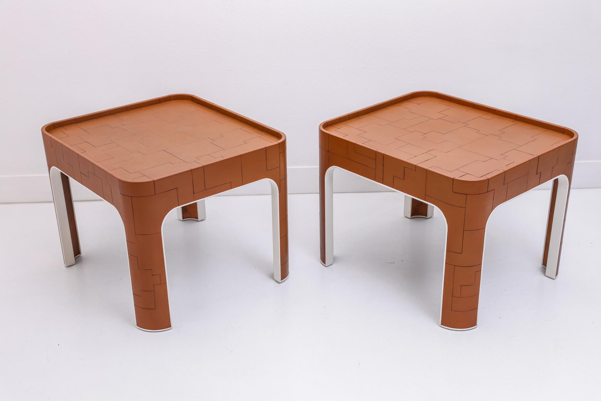 This pair of side tables were designed by John Dickinson and were put into production by San Francisco based furniture makers Randolf & Hein. Exhibiting all the hallmarks of Dickinson, the interior side of the legs are white lacquered. The top and