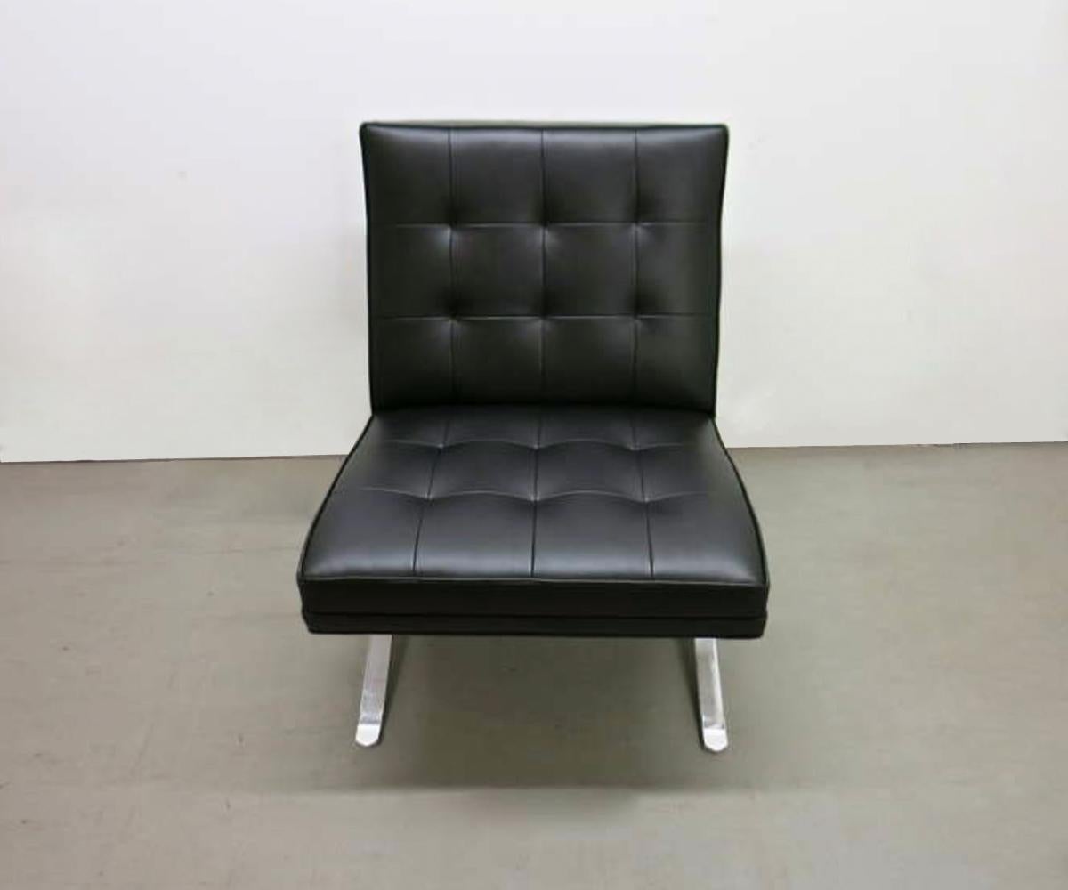 Pair of modern, armless lounge chairs by Mobilier International in excellent vintage condition; each have a tufted black leather covered seat, upholstered as shown approximately 4 years ago, and a polished steel base that has two played legs