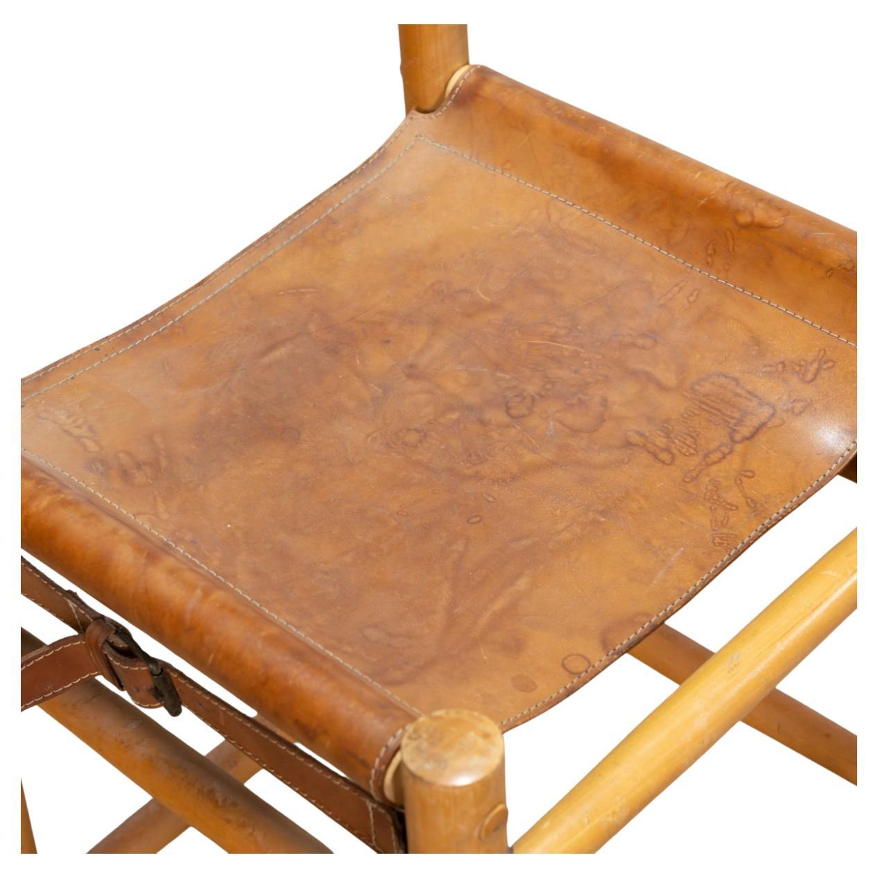 Pair of leather and wood dowel sling stools by Abel Gonzalez. Leather shows wear and use - seat backs have woven cloth design. Sold as a pair (2) stools. Made in Argentina. 

Each stool measures 18” x 19” x 40” high 
Seat heat is 28” high 