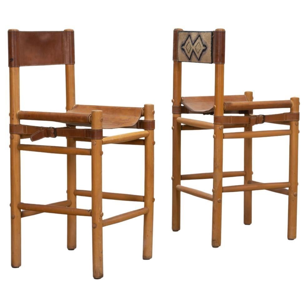 Pair of leather and wood sling stools by Abel Gonzalez