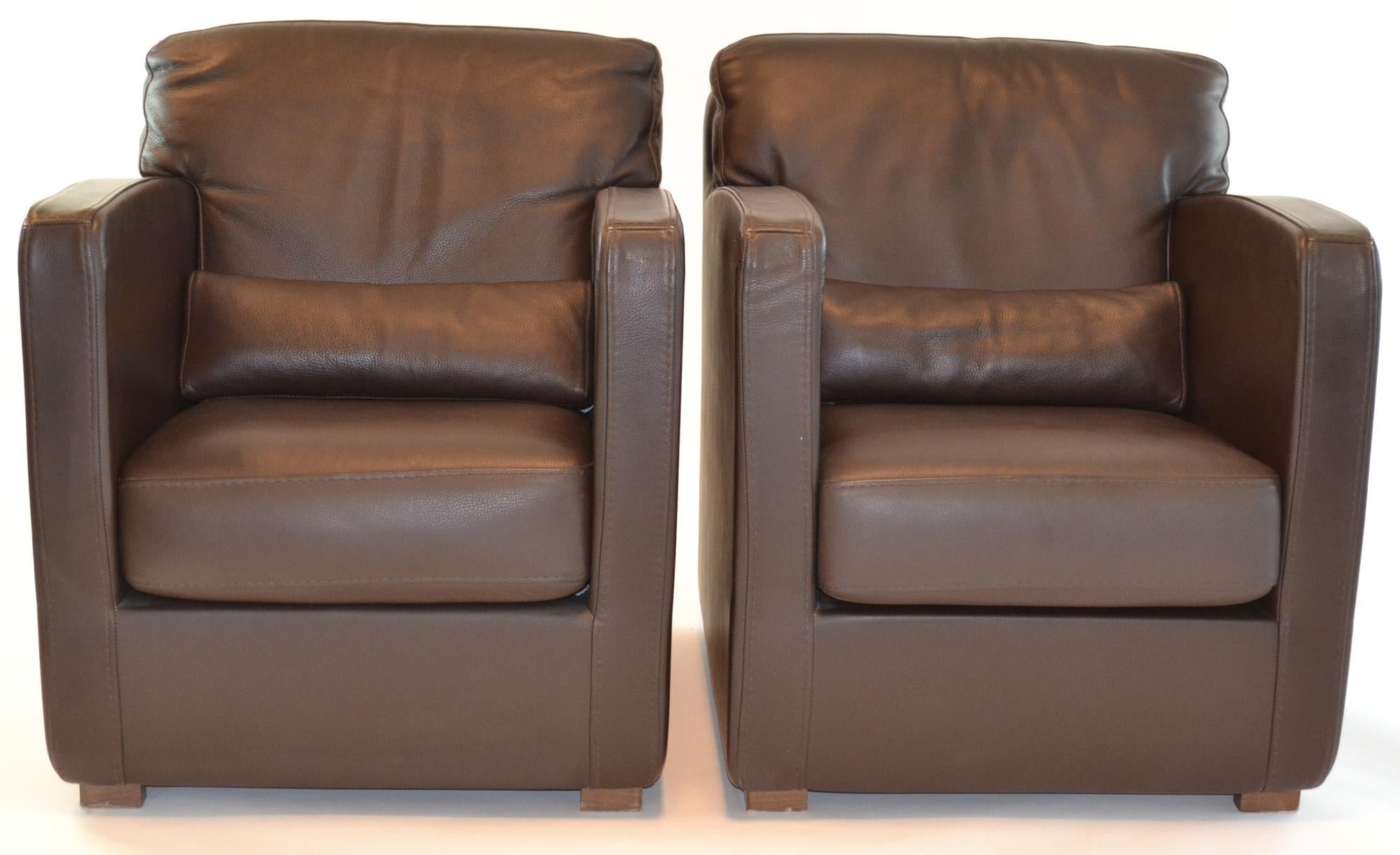 Pair of leather arm or club chairs by Roche Bobois in supple brown leather. Comfortable, diminutive yet masculine and adaptable. Lumbar roll. Wood slab feet. Signed.