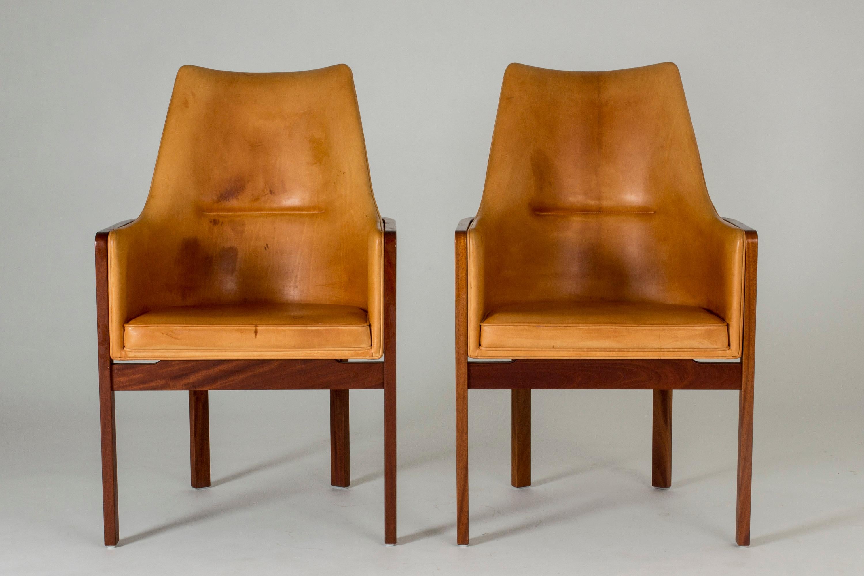 Pair of elegant armchairs by Bernt Petersen, with rosewood frames and comfortable natural leather seats and backs. Smooth lines with nicely contrasting materials. Leather in very good condition, but with some patina.
