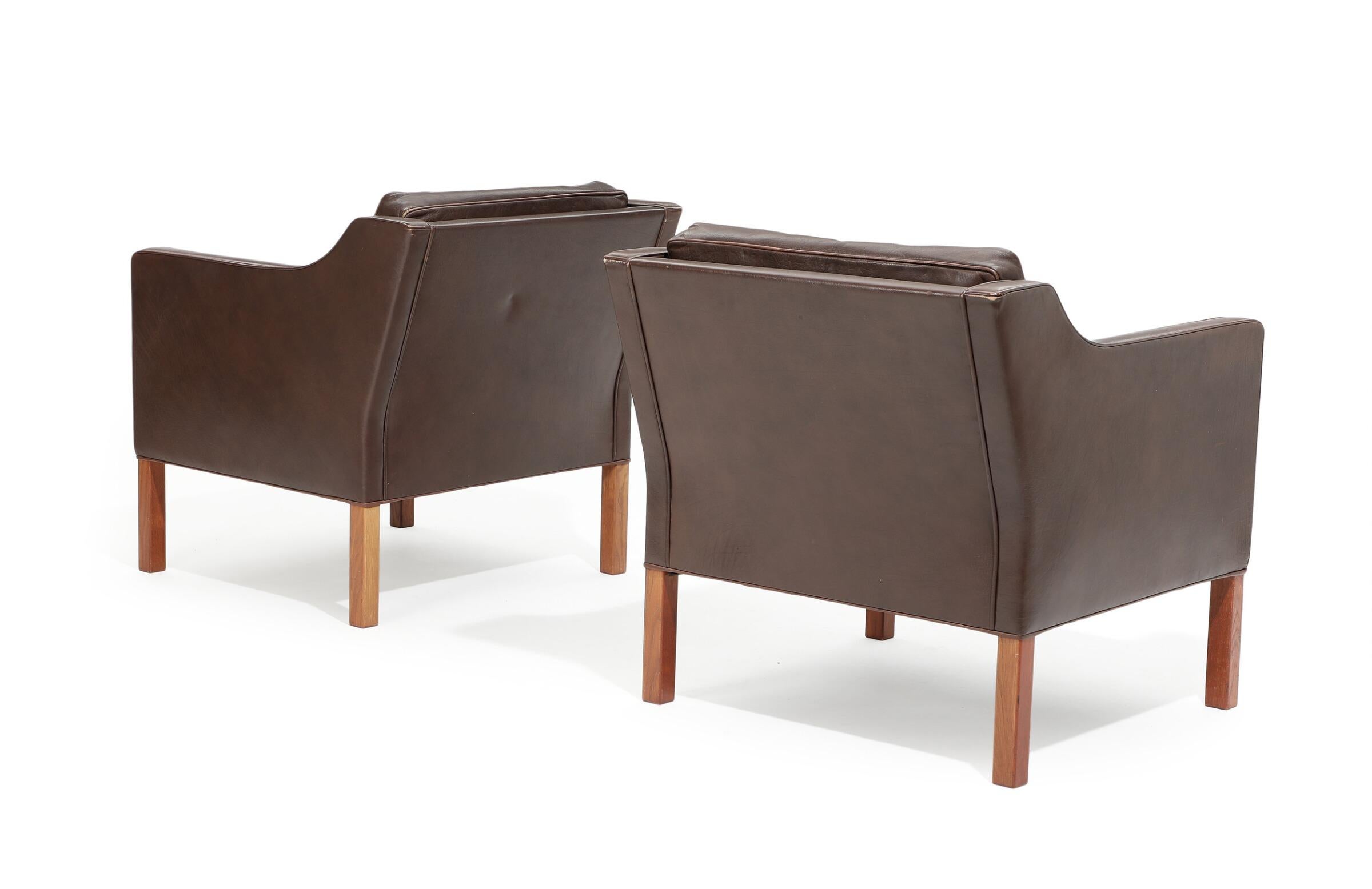 A pair of leather armchairs by Danish designer Børge Mogensen, with mahogany legs. A timeless and elegant design. Sides, back and cushions upholstered with brown colored leather. Model 2421. Manufactured and marked by Fredericia Stolefabrik.