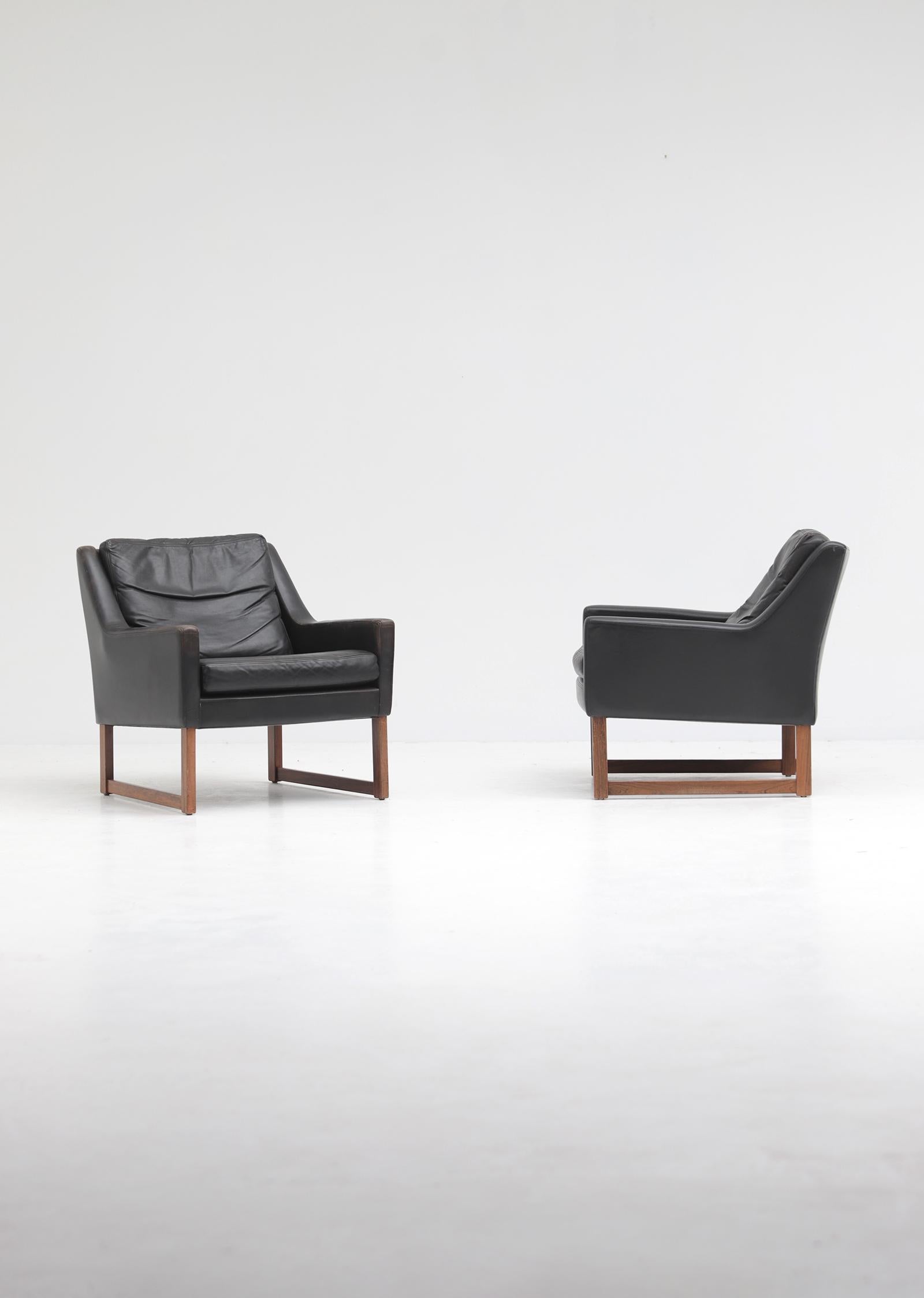 Ein Paar Ledersessel, entworfen in den 1960er Jahren von Rudolf Bernd Glatzel für Kill International, Deutschland. Beide Stühle haben einen Holzrahmen und sind mit schwarzem Anilinleder gepolstert. Die Stühle haben lose Kissen, die mit Federn