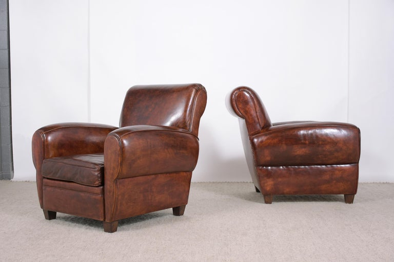 An extraordinary pair of art deco-style lounge chairs are hand-crafted out of wood and leather combination, are in great condition, and have been professionally restored by our craftsmen team. The lounge chairs feature comfortable wide backrests, a