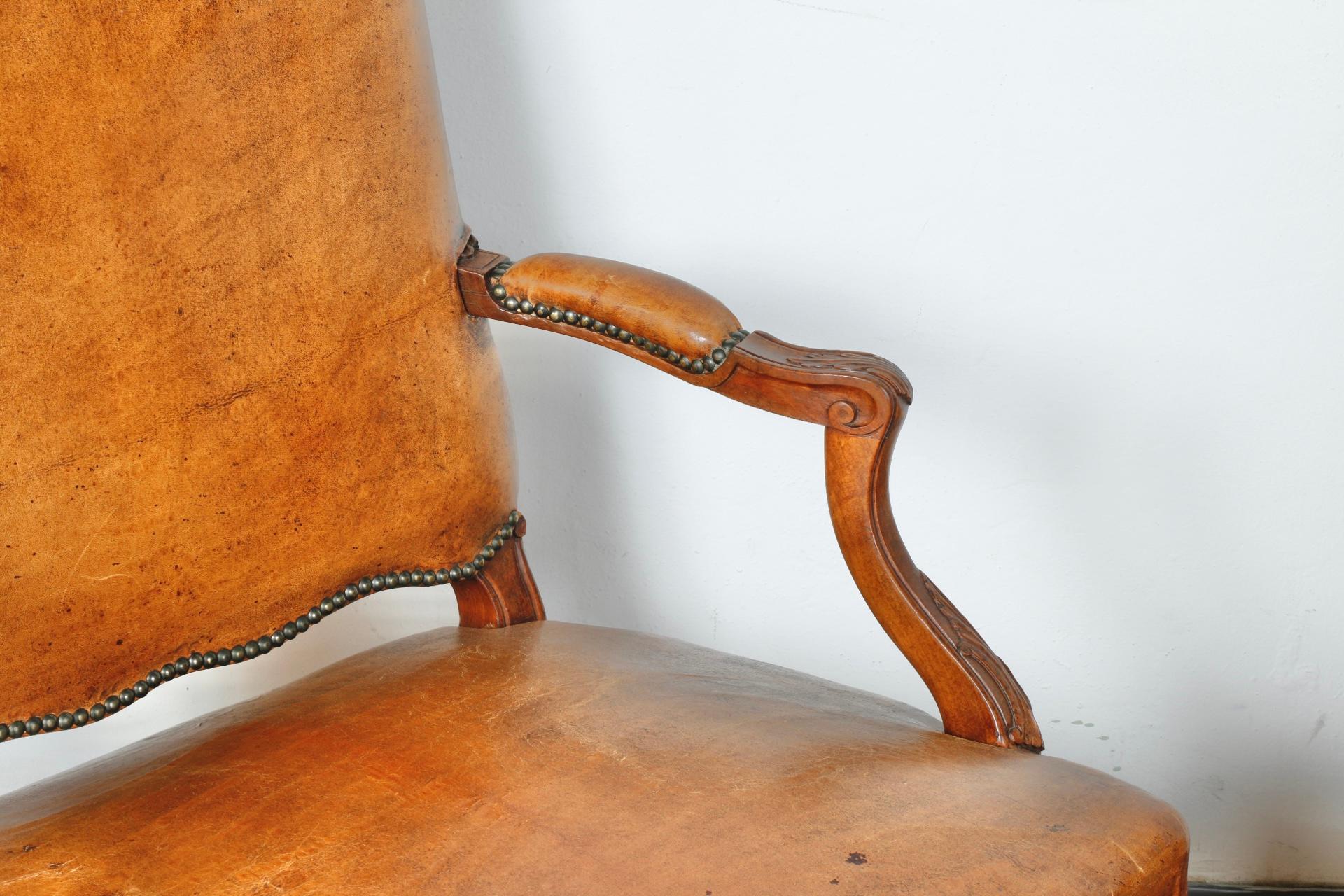 Pair of well kept old Bergere arm chairs. Leather is well kept and clean. Wooden carved base has nice detailed design. Very comfy able. 

