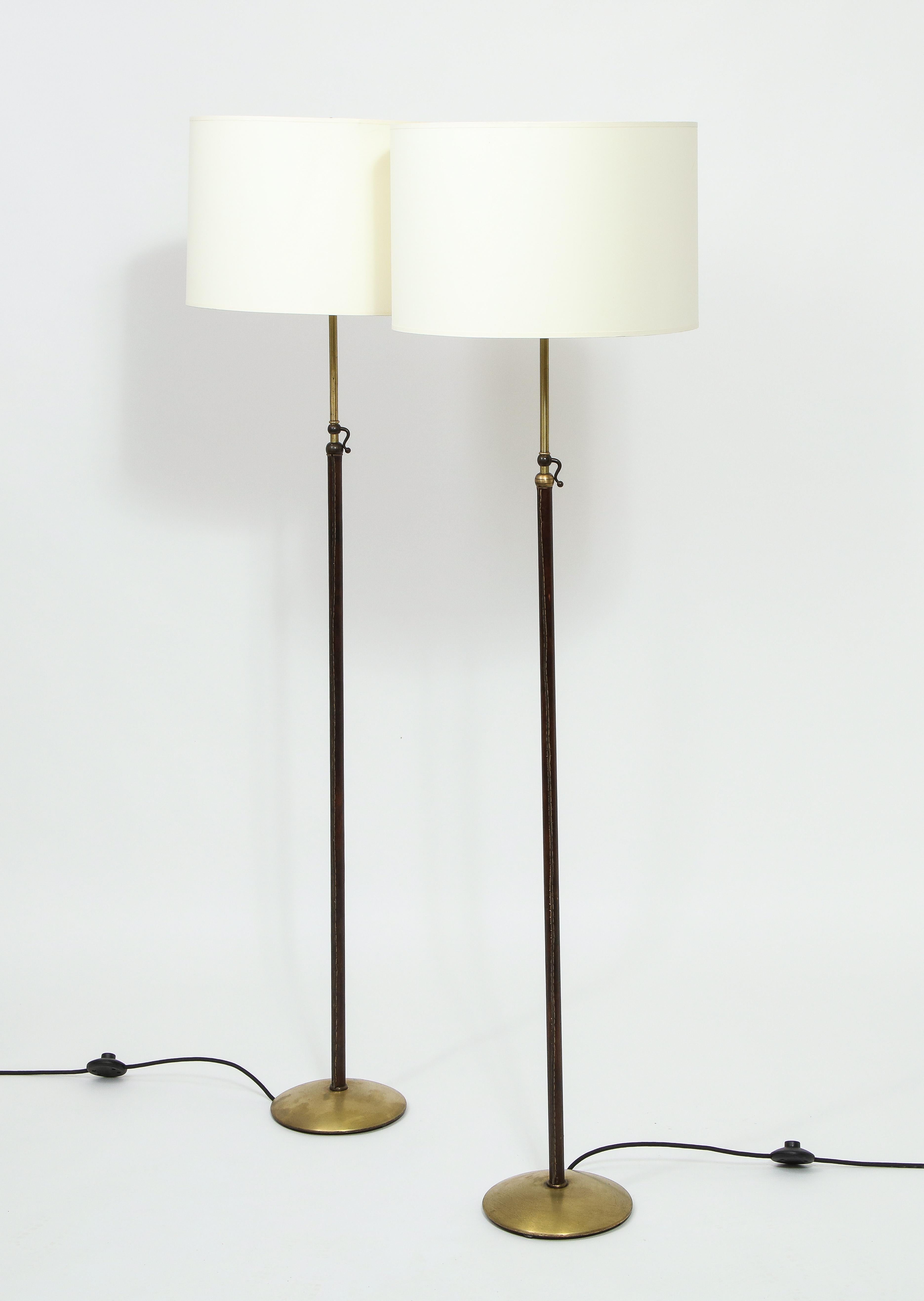 Adjustable pair of standing lamps by Jacques Adnet, Leather over brass.
*Lampshades aren't included but available on request