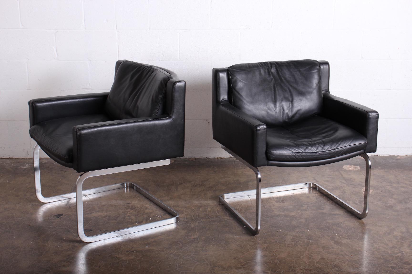 A pair of leather armchairs with chrome bases. Designed by Robert Haussmann for Stendig.