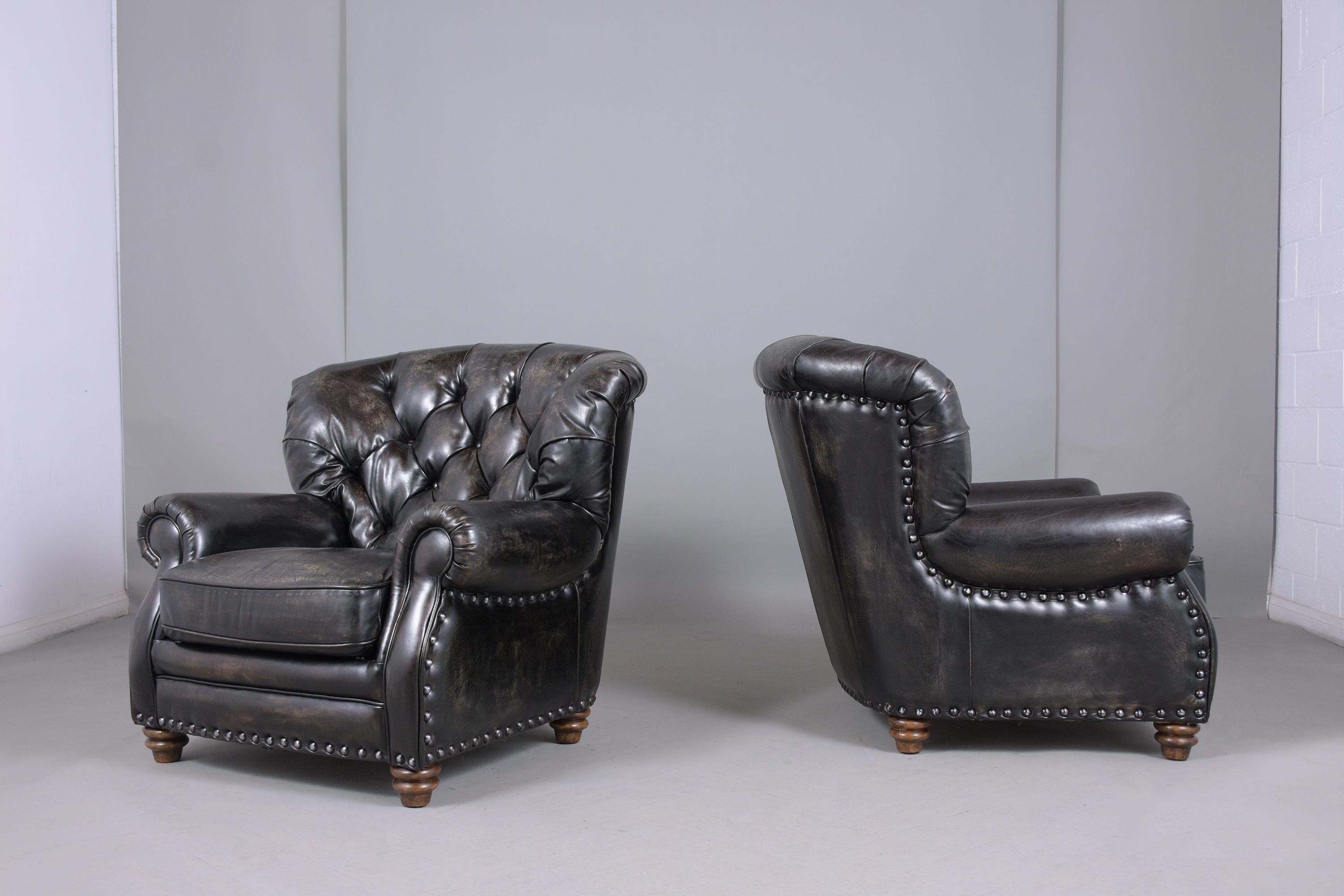 An extraordinary pair of vintage armchairs These lounge chairs are in great condition and features brass nailheads trim details leather upholstery with a tufted design, comfortable removable seat cushions, and these chairs are dyed in black color