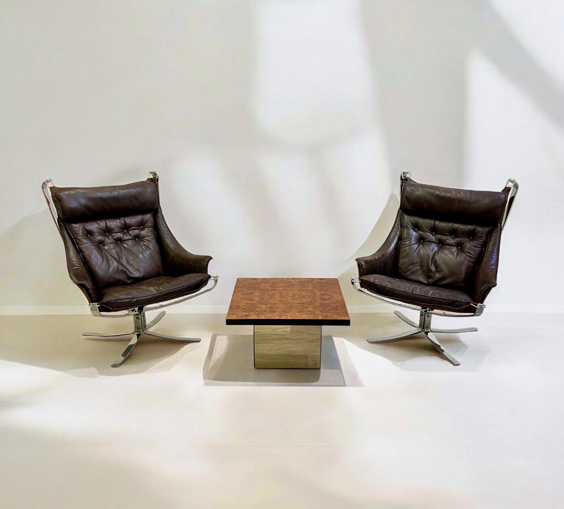 A smart pair of leather and chrome Falcon Armchairs designed by Sigurd Resell (1920-2010).

The Falcon chair features a sleek, minimalist silhouette with clean lines and gentle curves, embodying mid-century modern elegance. The chair’s low profile