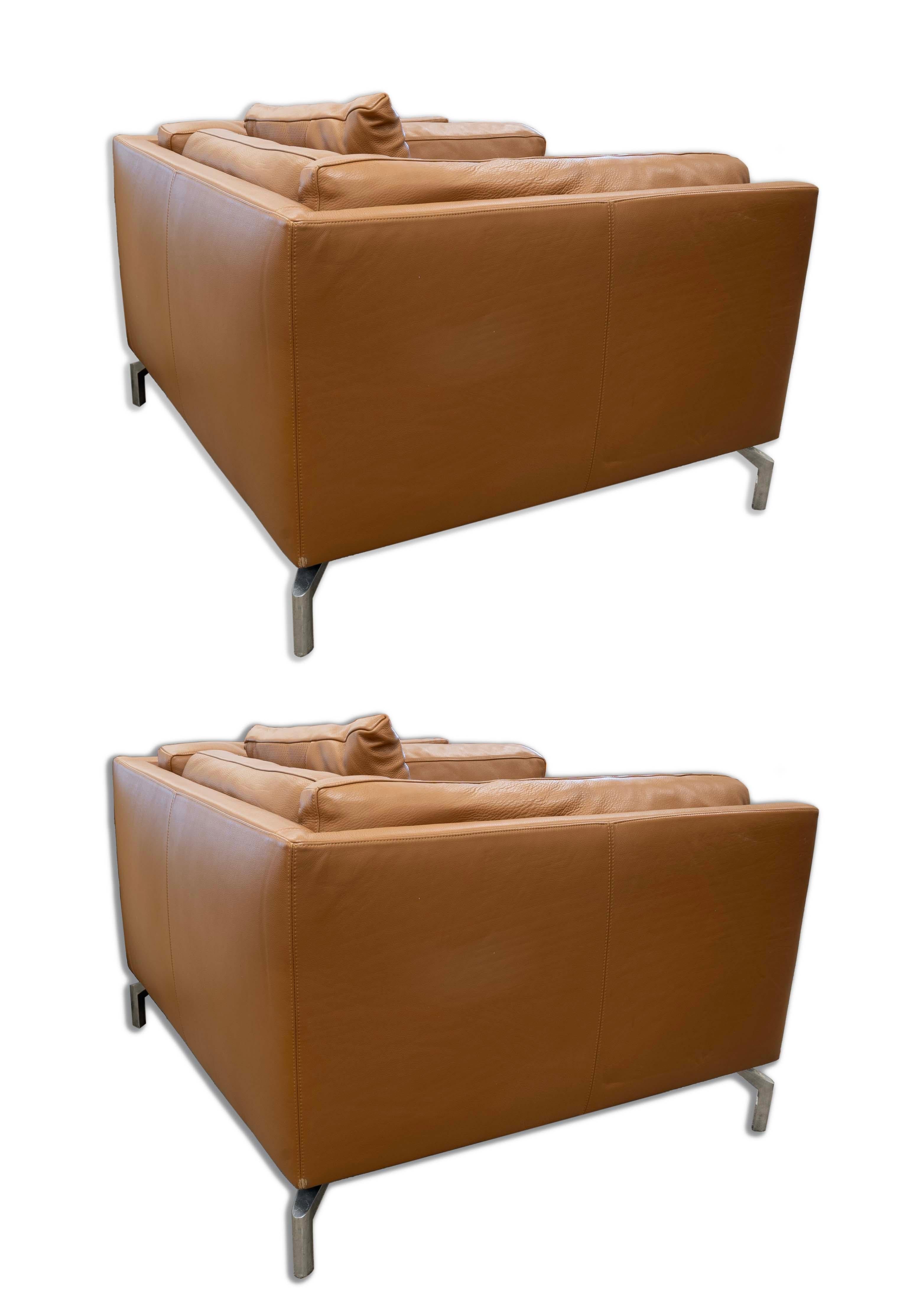 Elevate your living space with this luxurious pair of Leather Comolino Armchairs by renowned designer Giorgio Soressi. These contemporary modern armchairs boast a rich, tan leather finish that exudes sophistication and comfort. The sleek,