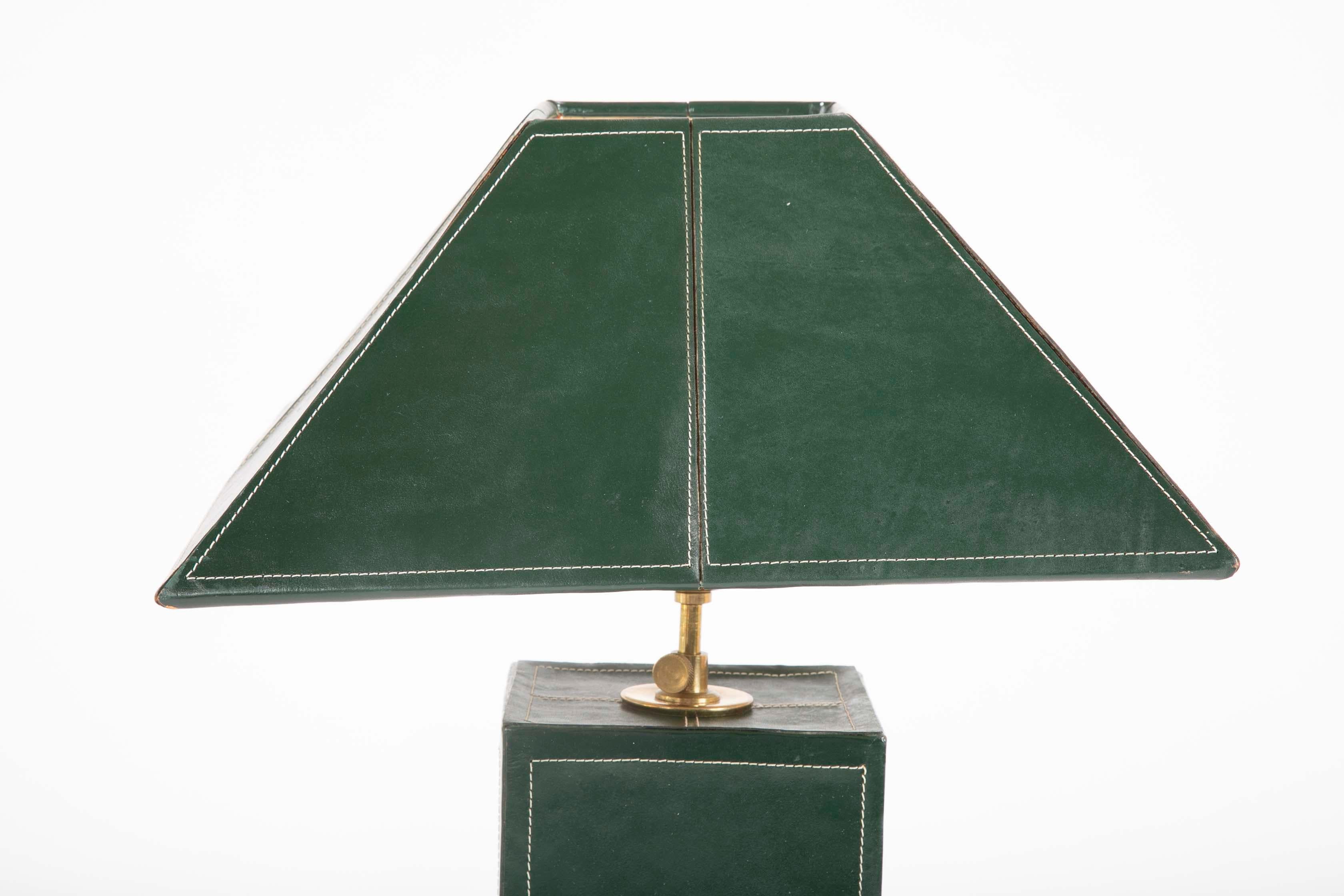 A pair of lamps covered in green leather with white stitching in the manner of Jacques Adnet.