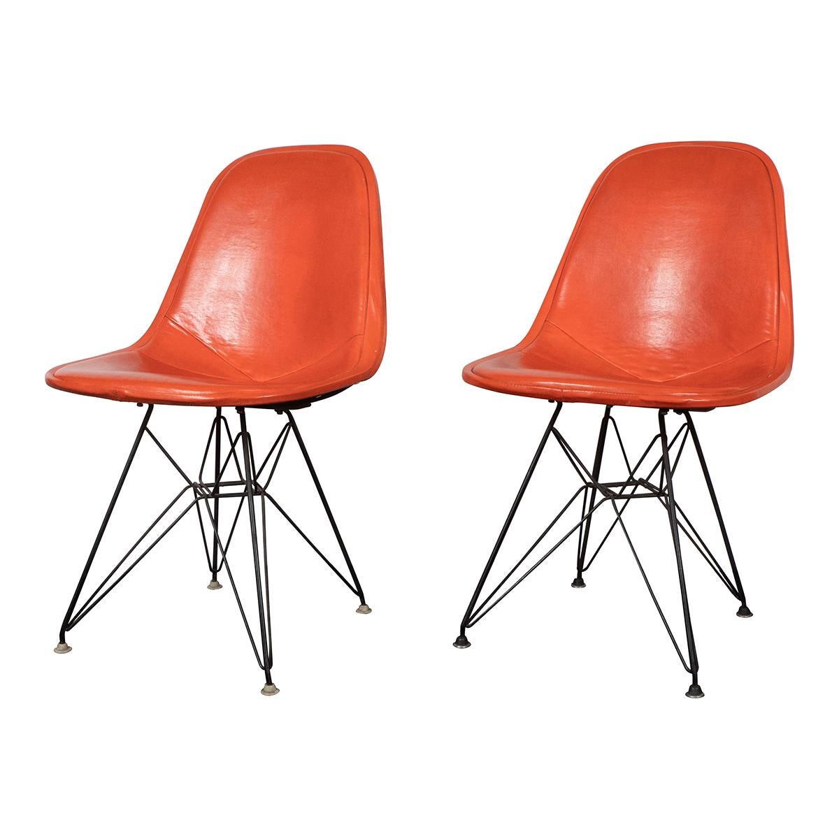 Pair of orange leather Eames DKX-1 side chairs for Herman Miller with original labels. Two pairs available. Sold as-is. Please note wear in leather upholstery.