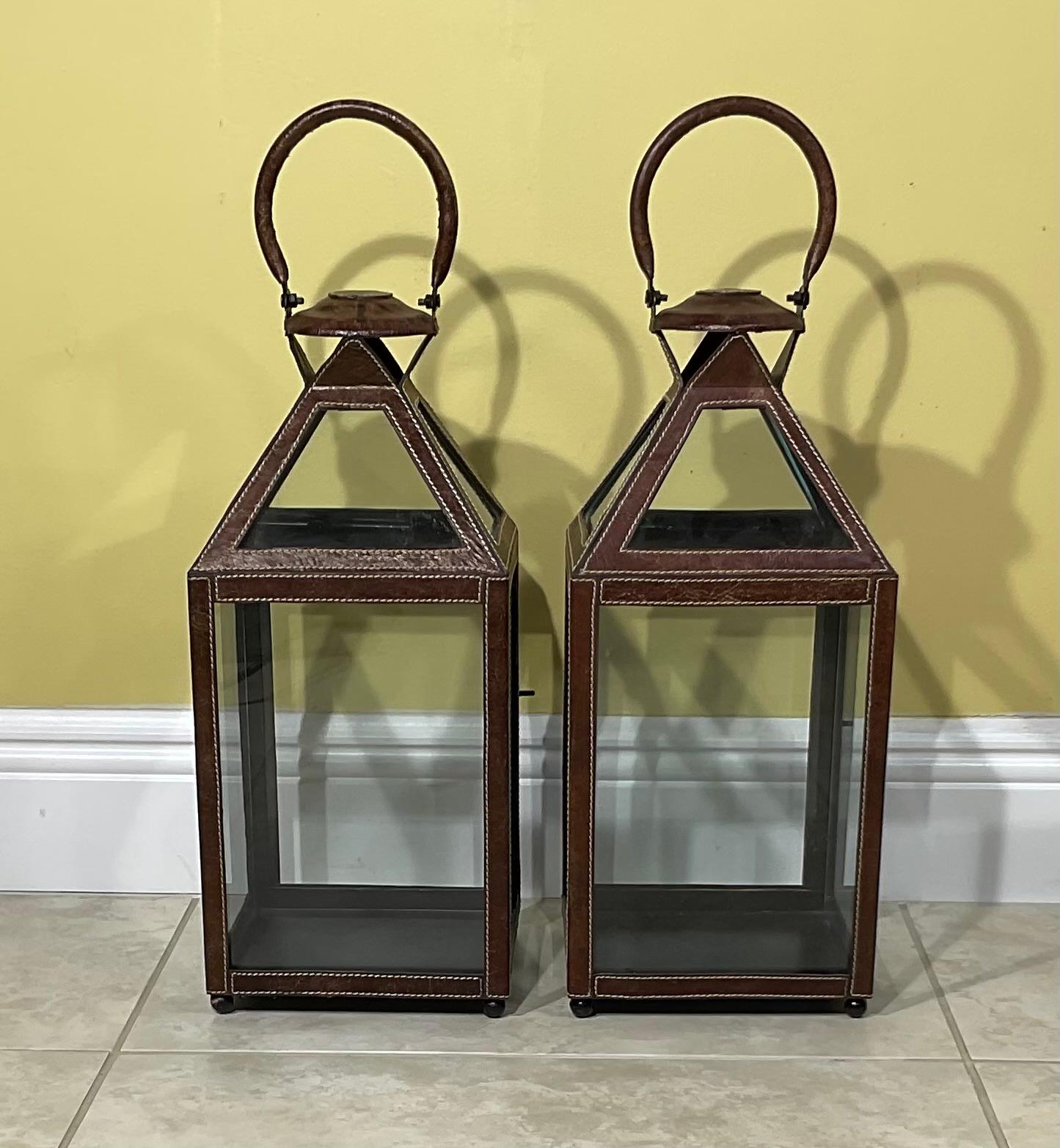 Elegant  pair of lantern made of metal frame , covered with nicely trim of leather faux . Glass around for good light exposure.