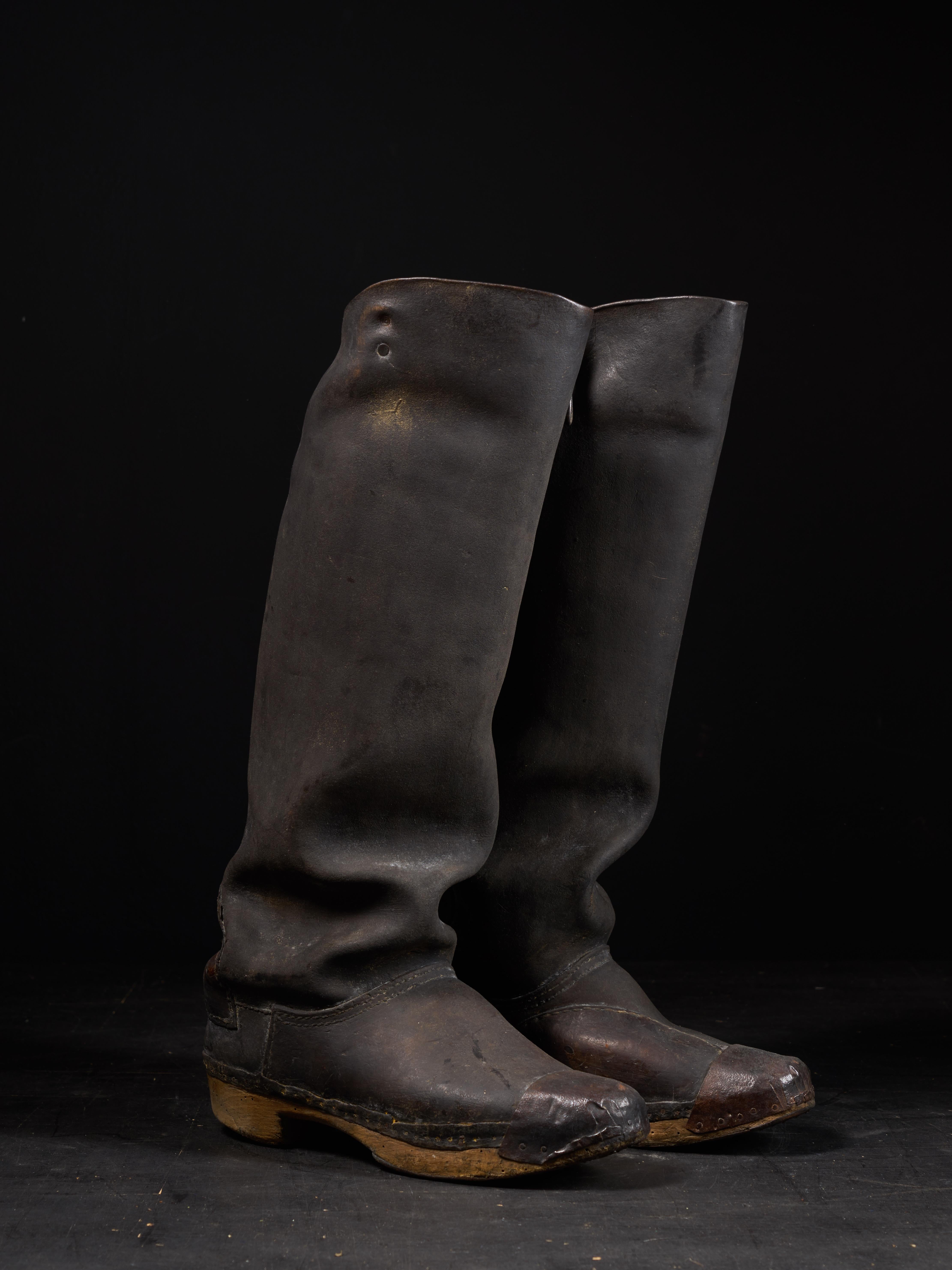 These are a pair of black leather high rise boots from the first half of the 20th century. It is plausible these were riding boots worn by men during the hunt or during a horseback riding trip as leisure.