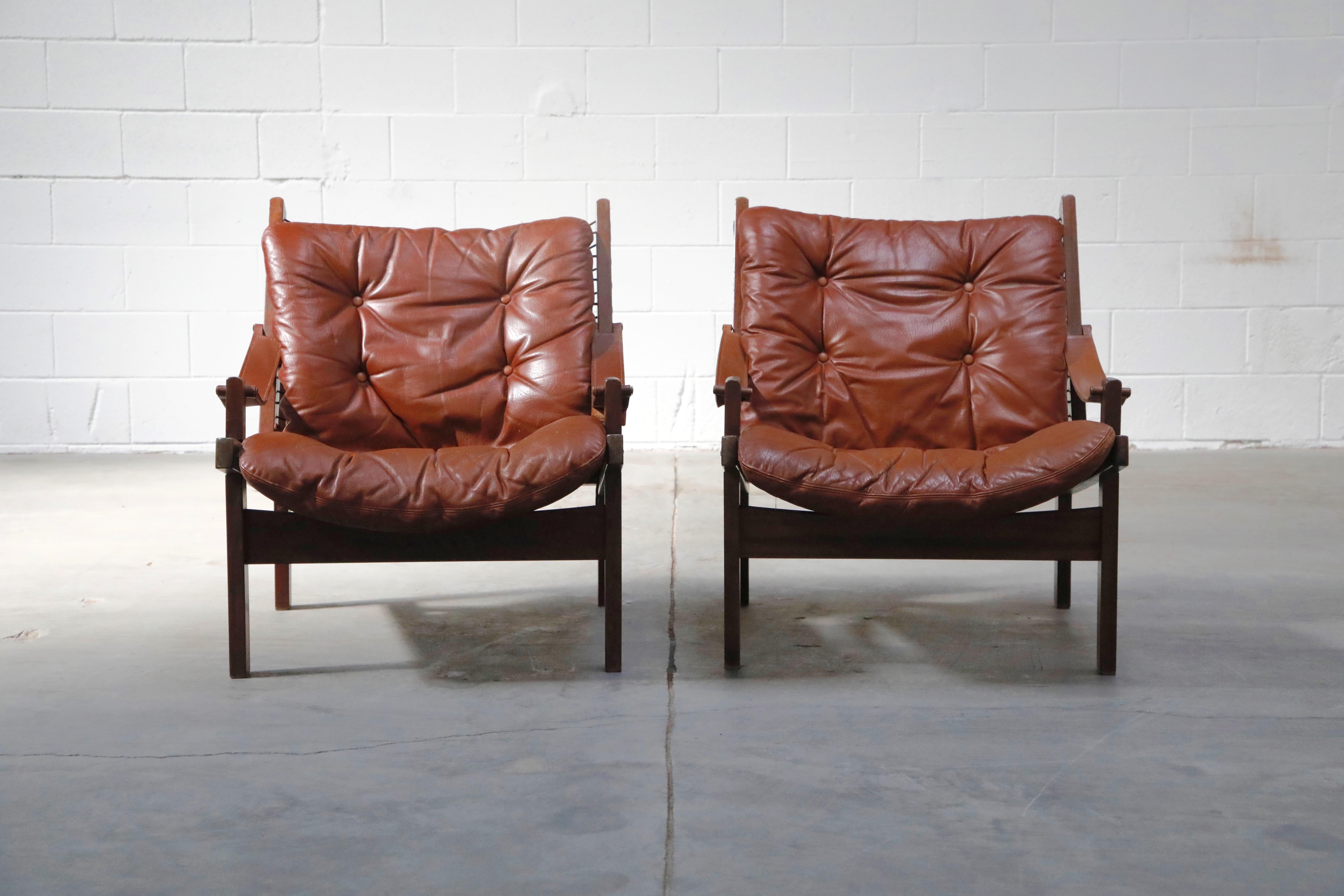 These super cool and laid back pair of leather 'Hunter' safari easy chairs are by Torbjørn Afdal for Bruksbo, 1960s, Sweden. Rare to find in the US, these Scandinavian Modern lounge chairs are the perfect option for someone who wants rare