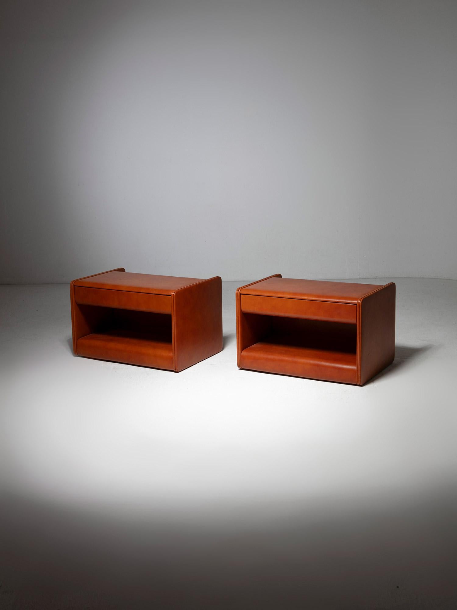 Pair of night stands by Luigi Massoni for Poltrona Frau.
Fully leather covered pieces, featuring a front drawer and large opening.
Back with aluminum pocket to hold books.
