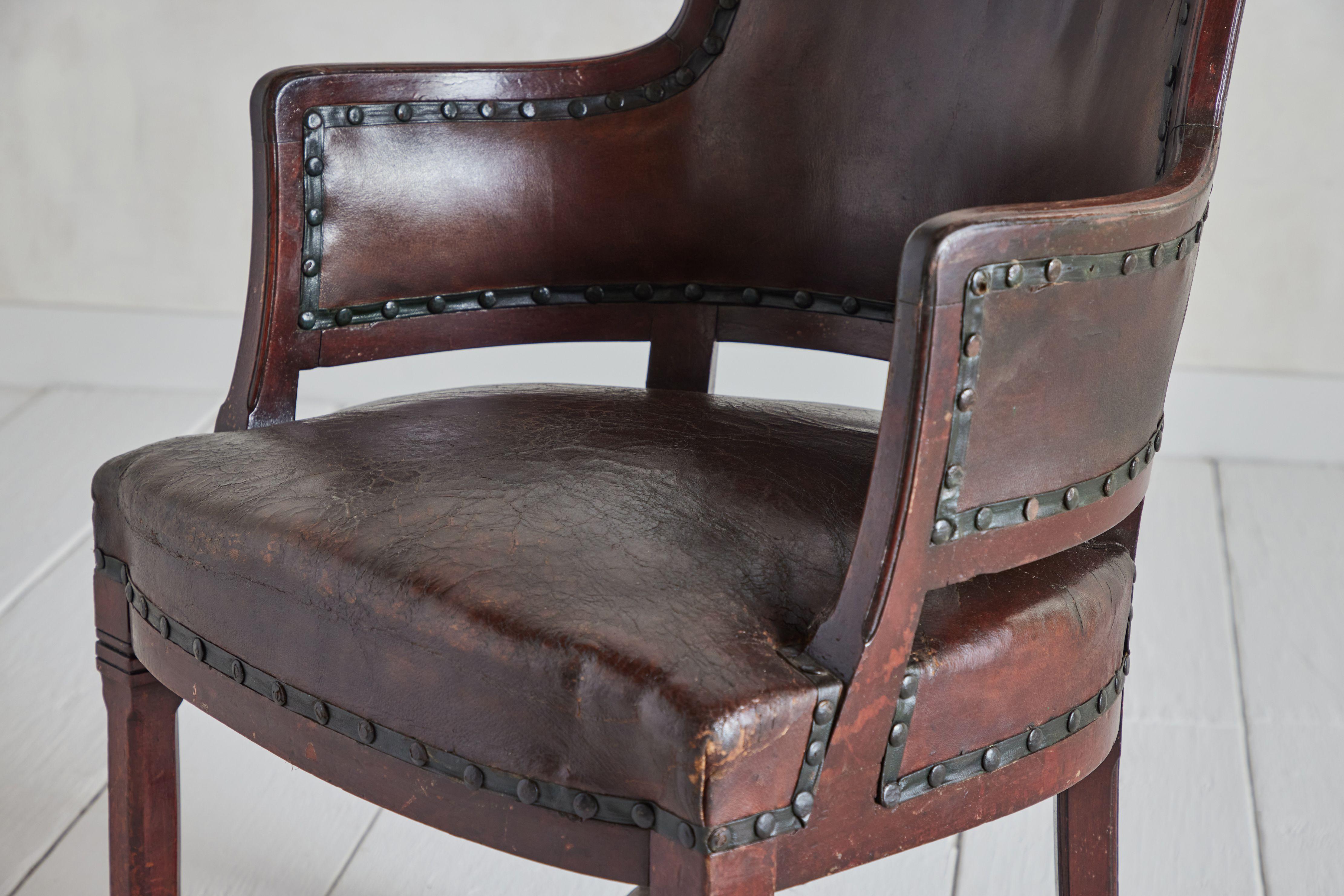 Pair of vintage leather pull up chairs made from wood and leather with nail head detailing. Leather has visible wear that is consistent with age and use. France circa 1930. 

Good vintage condition. Leather has visible wear that is consistent with