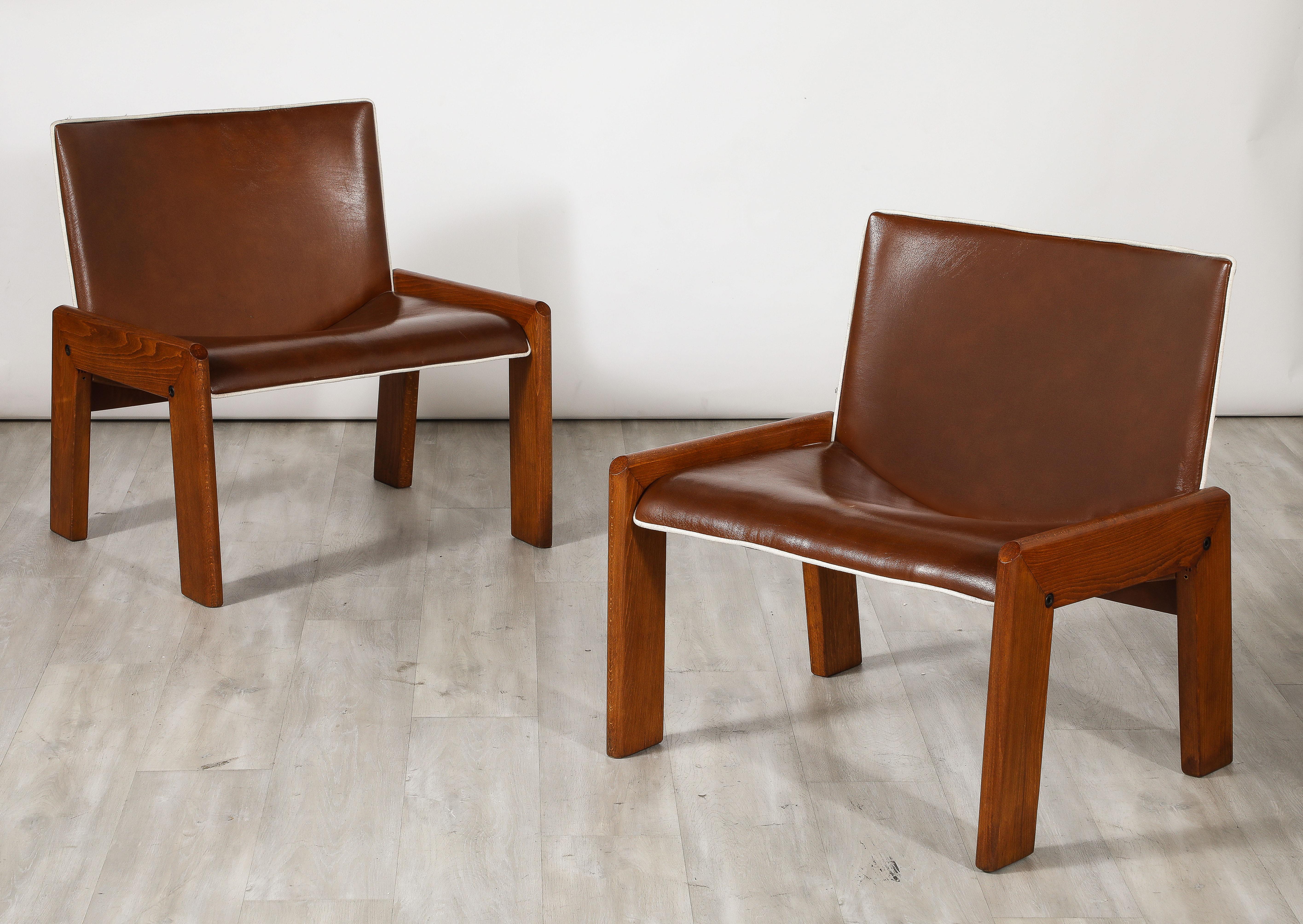 A chic pair of walnut side chairs by B&T Gruppo Industriale Salotti. The wide chocolate brown leather seats and backs with crisp white leather piping are supported on angular and sturdy walnut legs.  Very comfortable and wonderful modernist design.