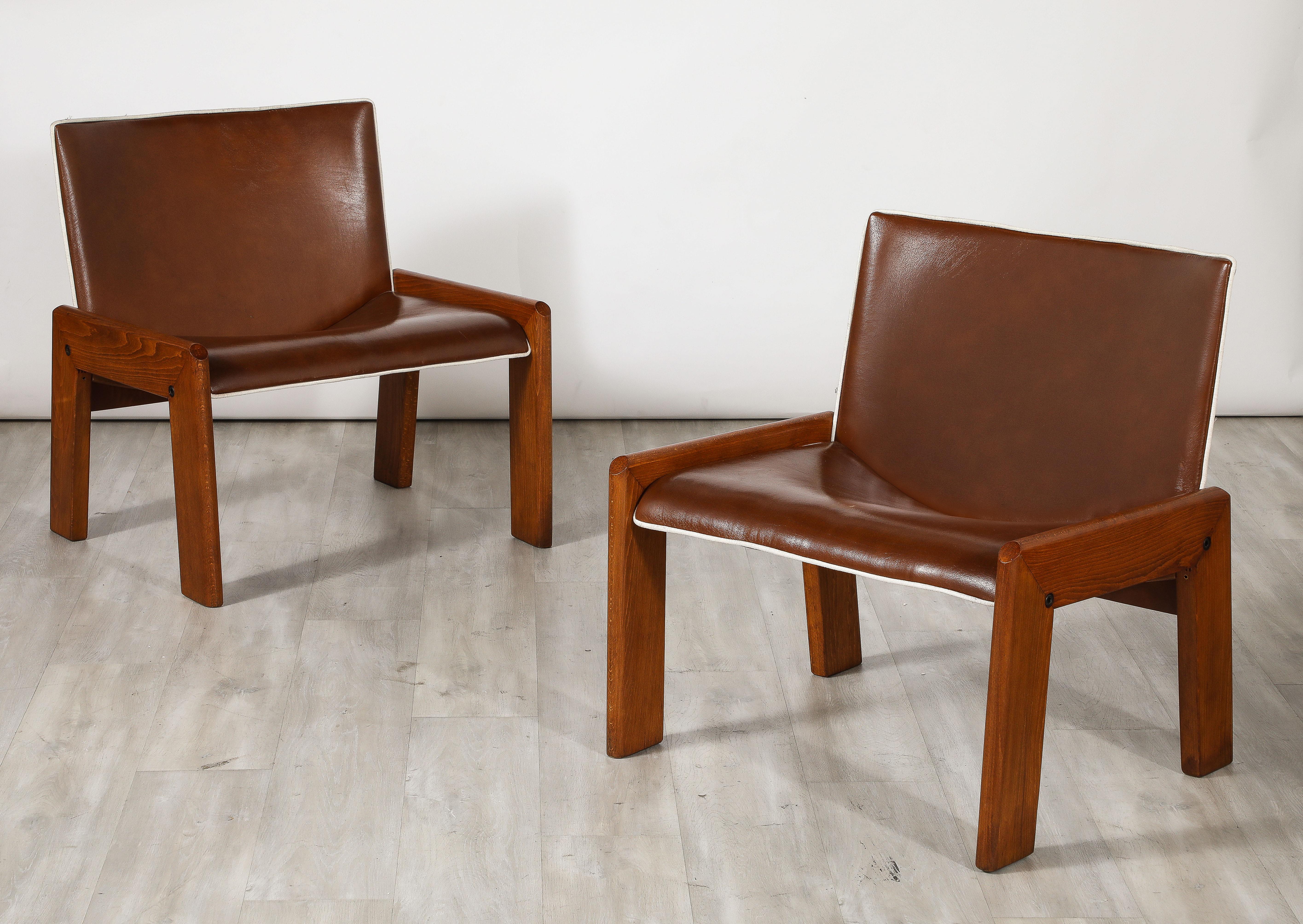 Un'elegante coppia di sedie in noce di B&T Gruppo Industriale Salotti. Gli ampi sedili e gli schienali in pelle marrone cioccolato con profili in pelle bianca sono sostenuti da gambe angolari e robuste in noce.  Molto confortevole e dal meraviglioso