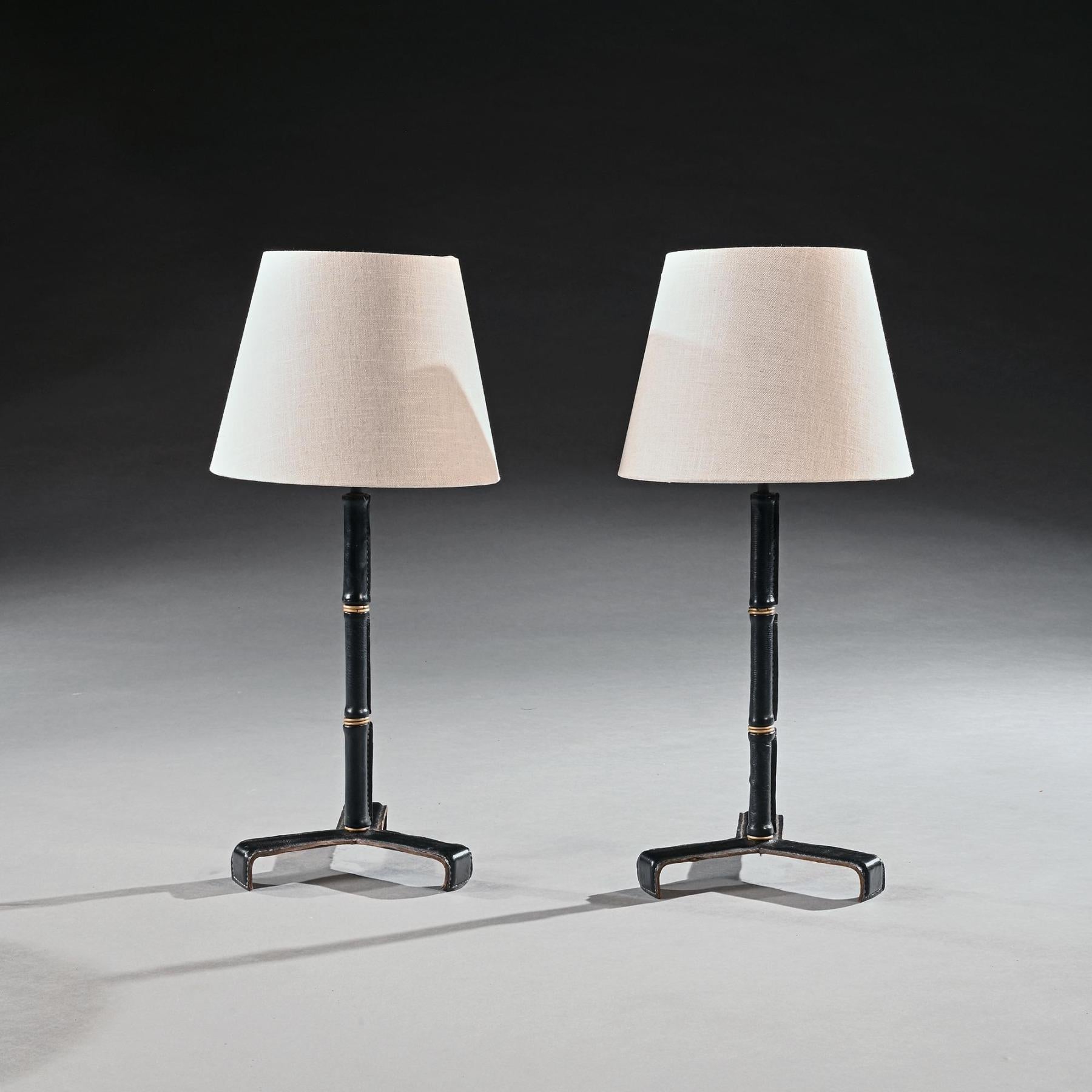 A fine pair of black leather and brass simulated bamboo table lamps attributed to Jacques Adnet.

French Circa 1955

These fine lamps are conceived in the mid-century chinoiserie manner, the central supports being rendered in the form of simulated