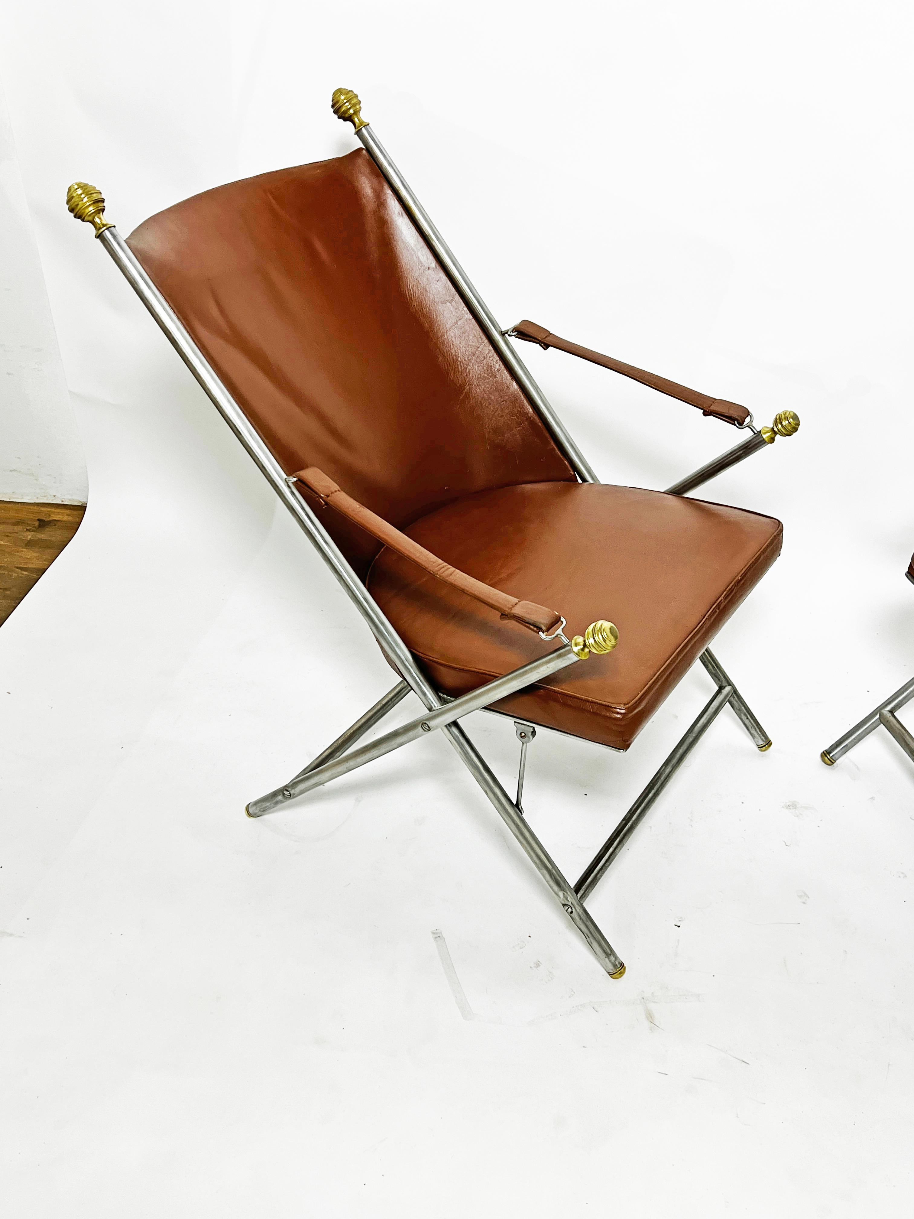 Pareja de sillones de campaña de cuero con armazón de acero cepillado y remates de bronce de estilo francés, ca. 1960.